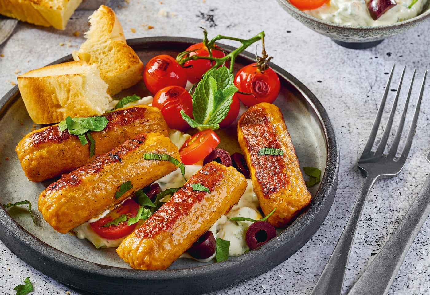 Cevapcici mit gegrillten Tomaten und Tzatziki-Feta-Salat | BILLA