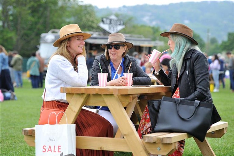 Ladies with drinks sitting at a bench at a show