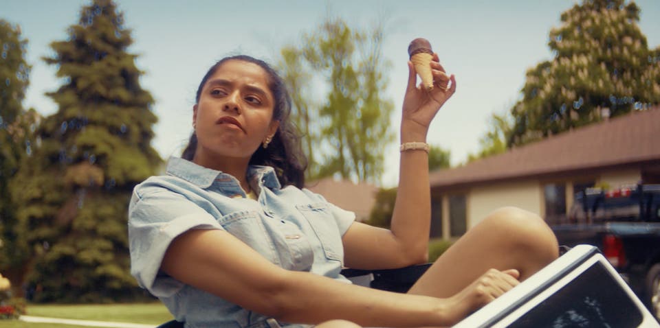 Woman driving mini care eating a Drumstick