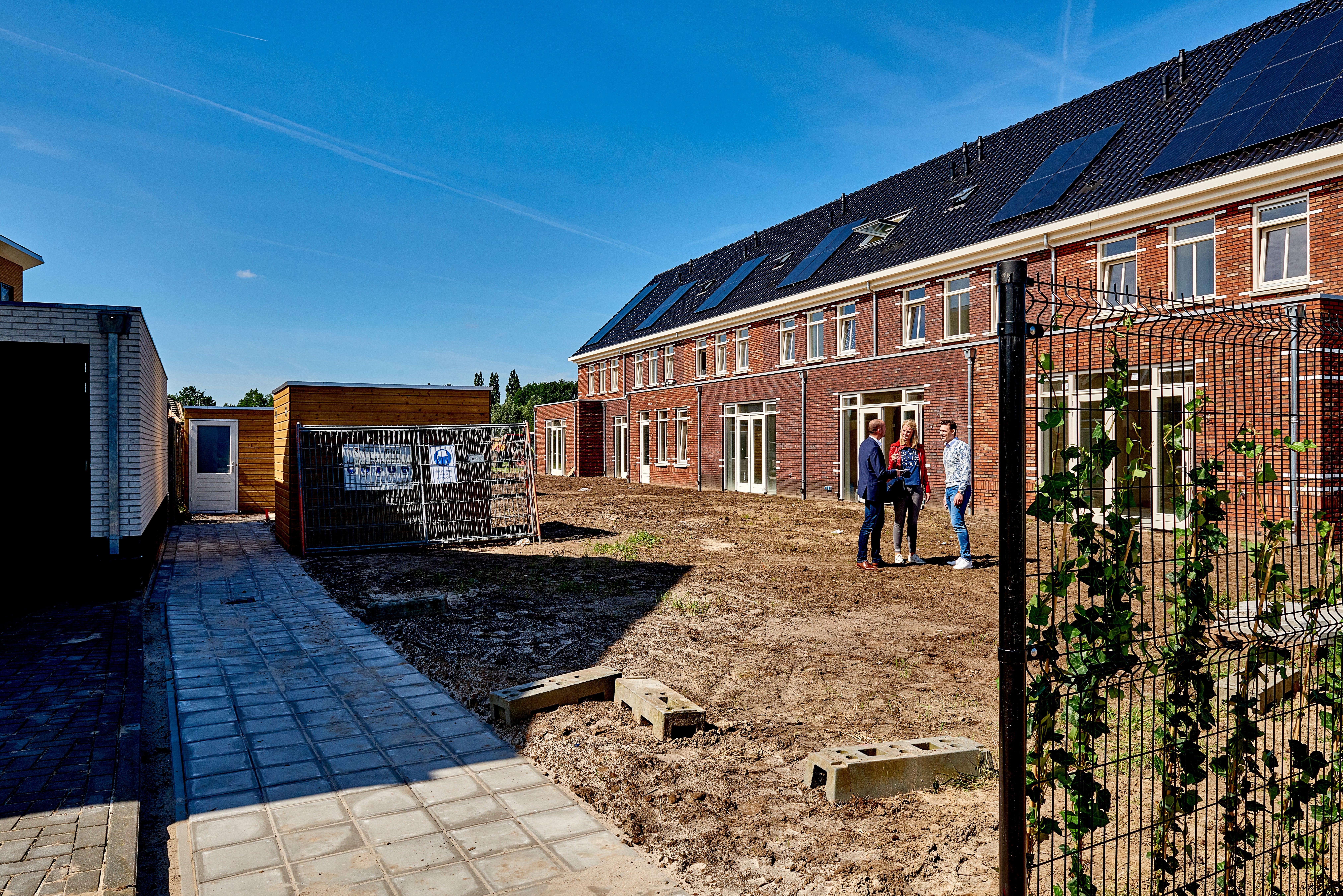 Groepje mensen in nieuwbouw tuin