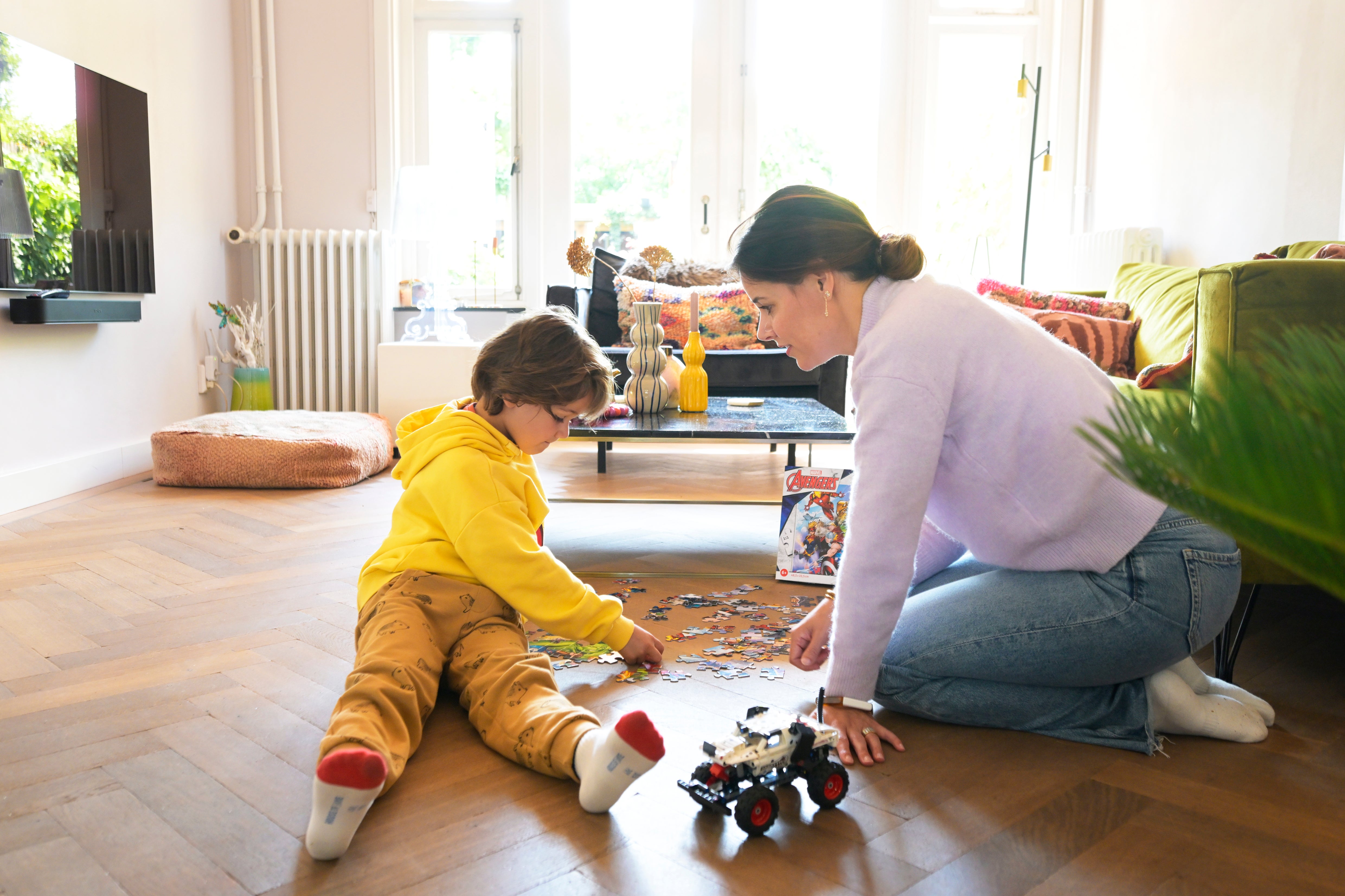 kind en vrouw maken puzzel op de vloer