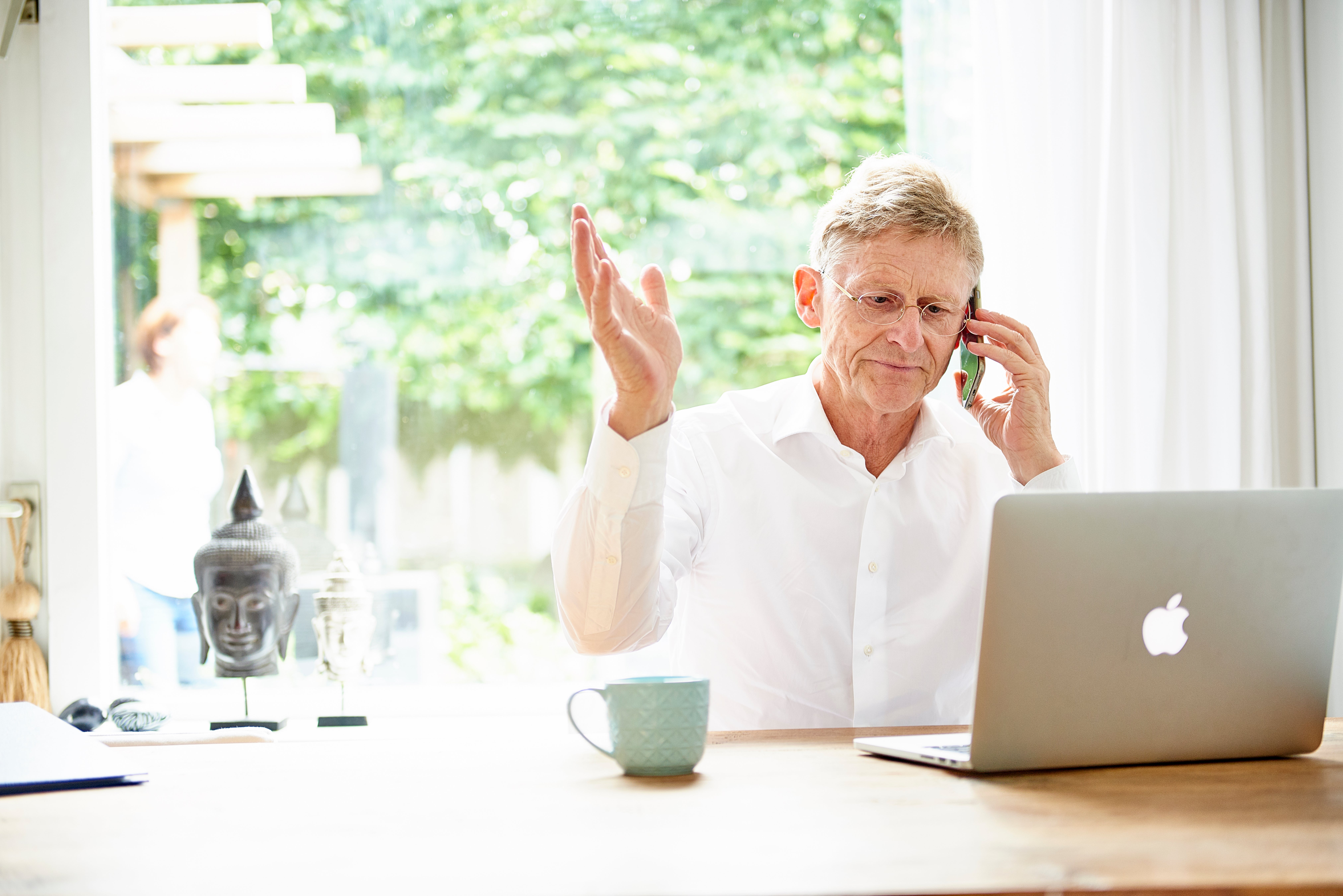 geïrriteerde man belt achter laptop