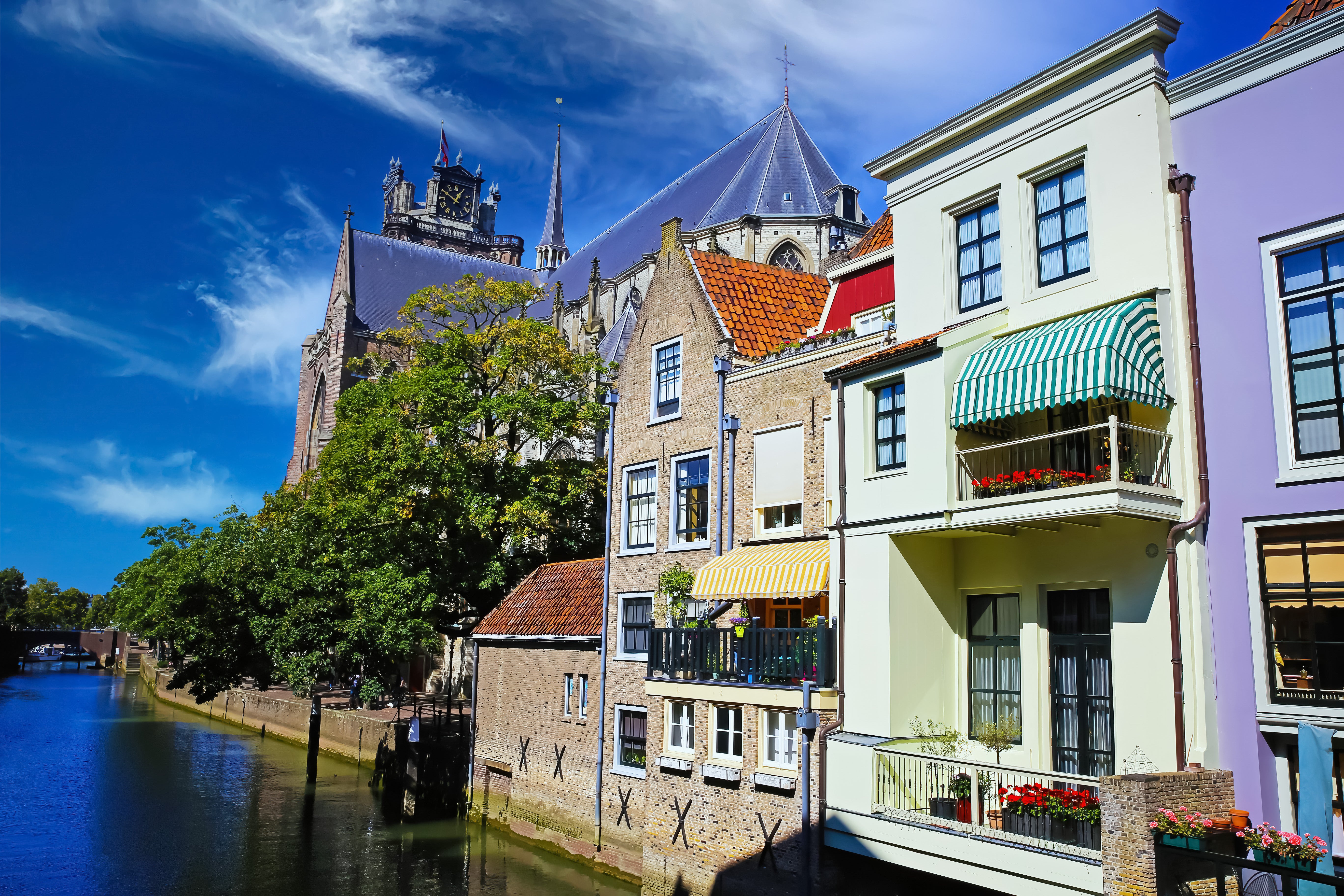Vrolijk gekleurde appartementen aan een rivier met balkons en zonneschermen