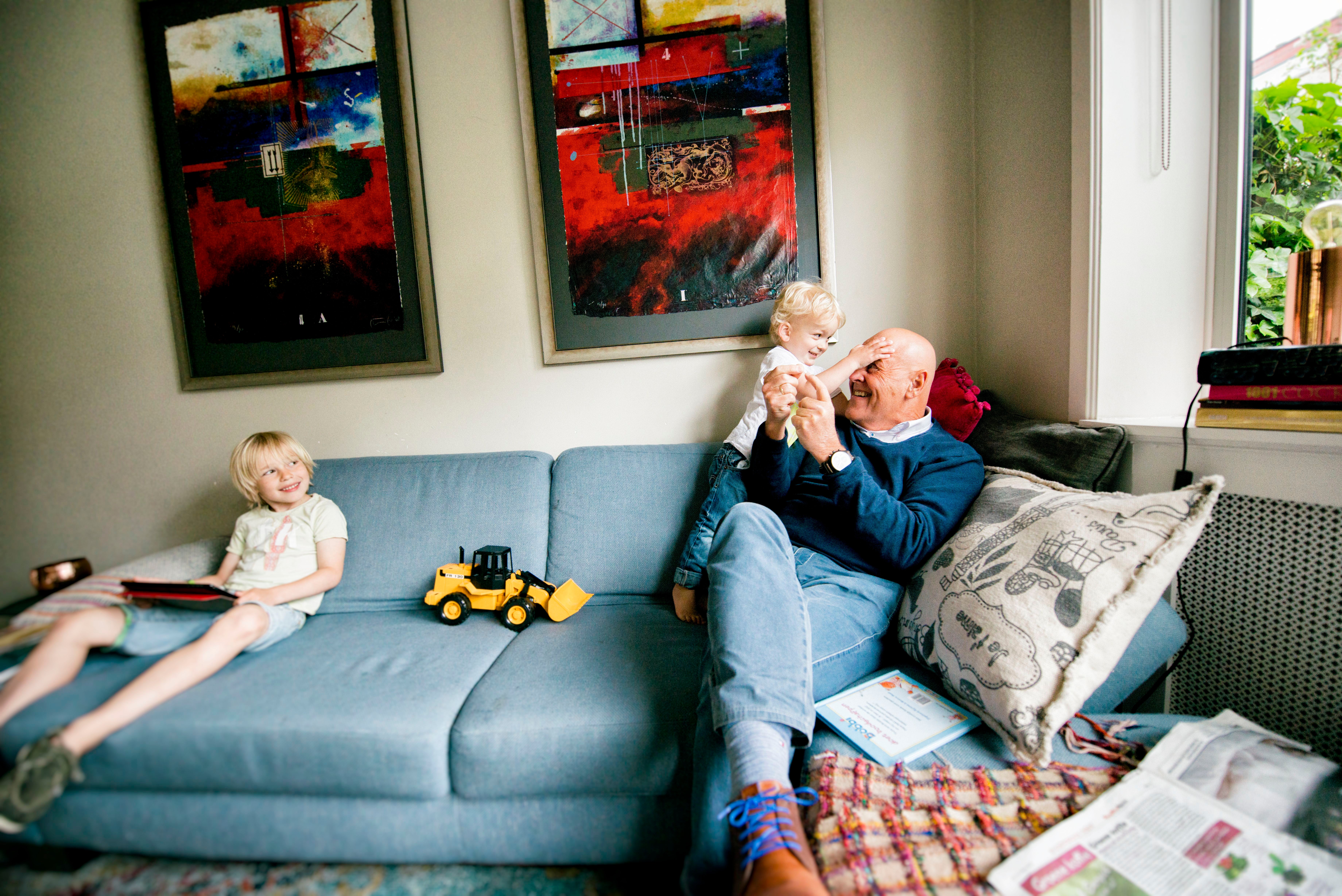 vader speelt met kinderen op bank