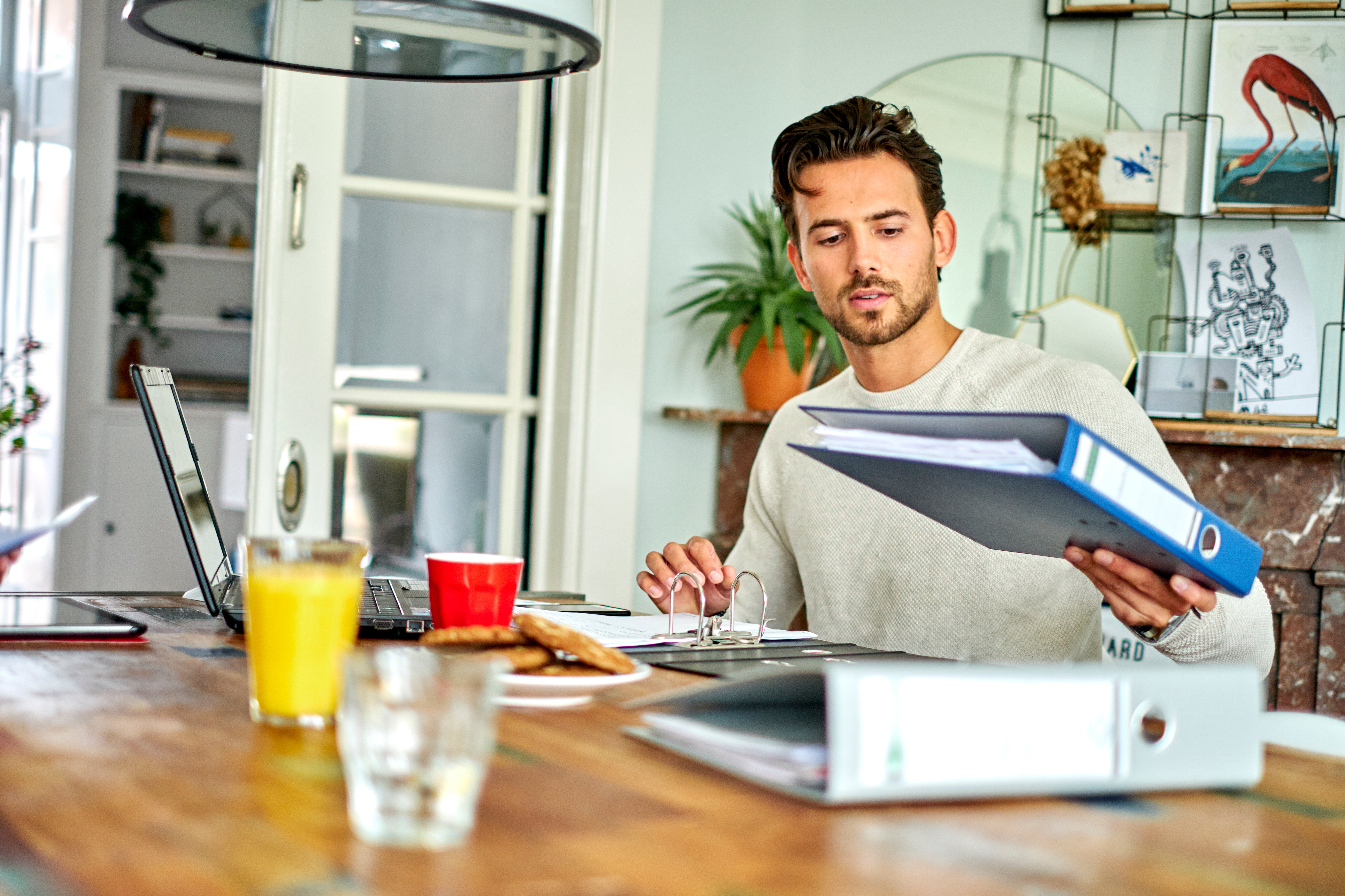 man aan tafel bekijkt map