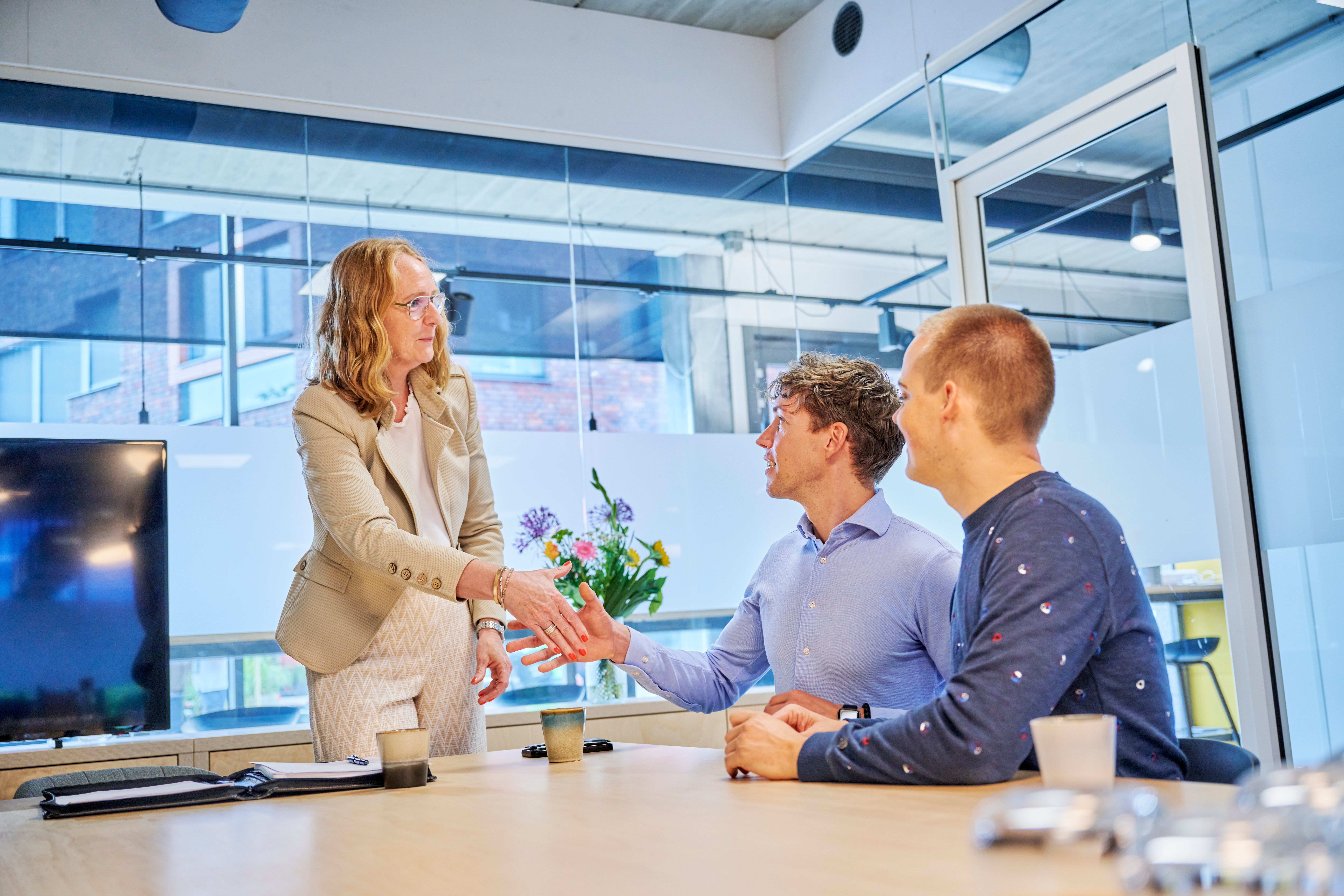 makelaar geeft hand aan mannen