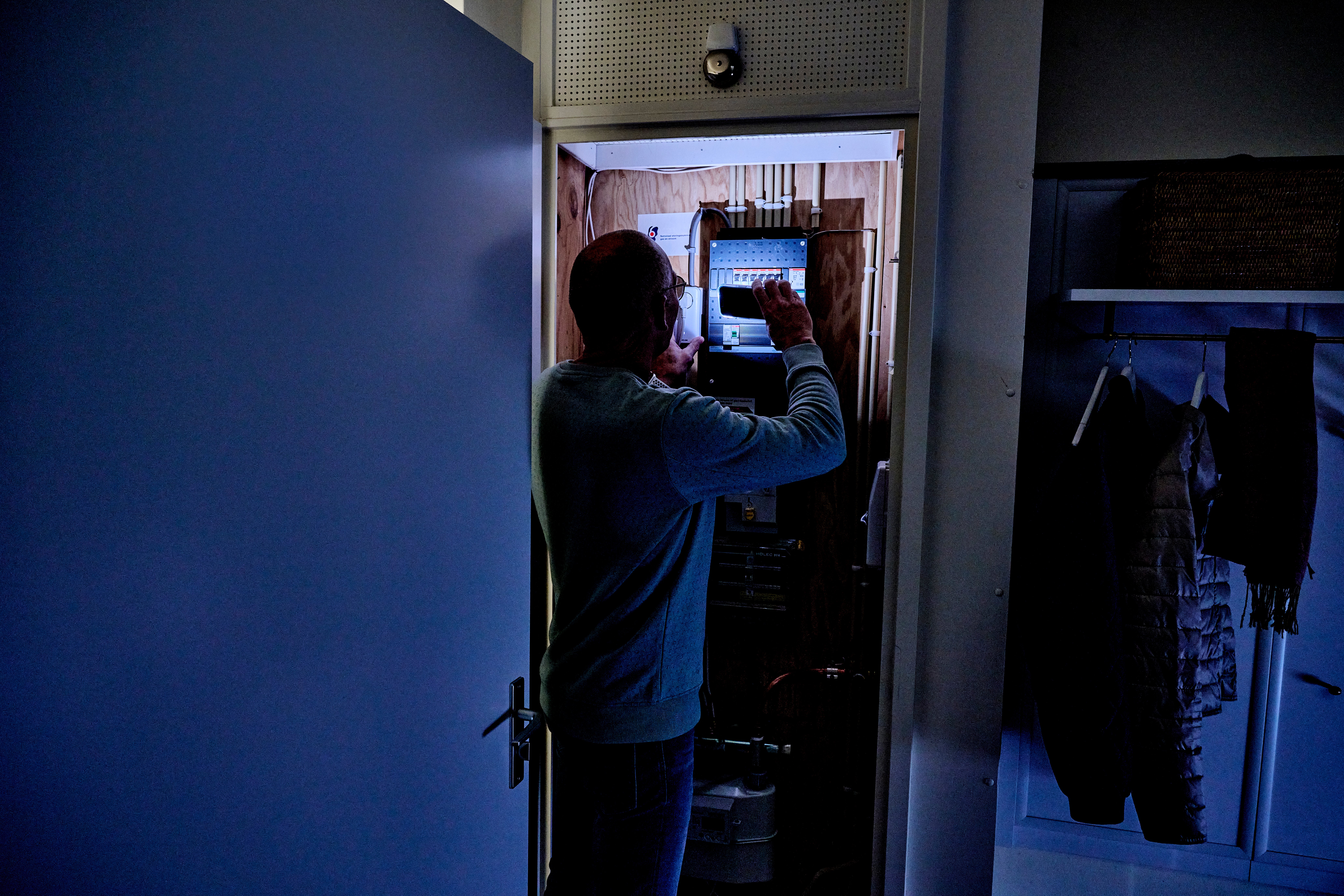 man controleert meterkast met zaklamp