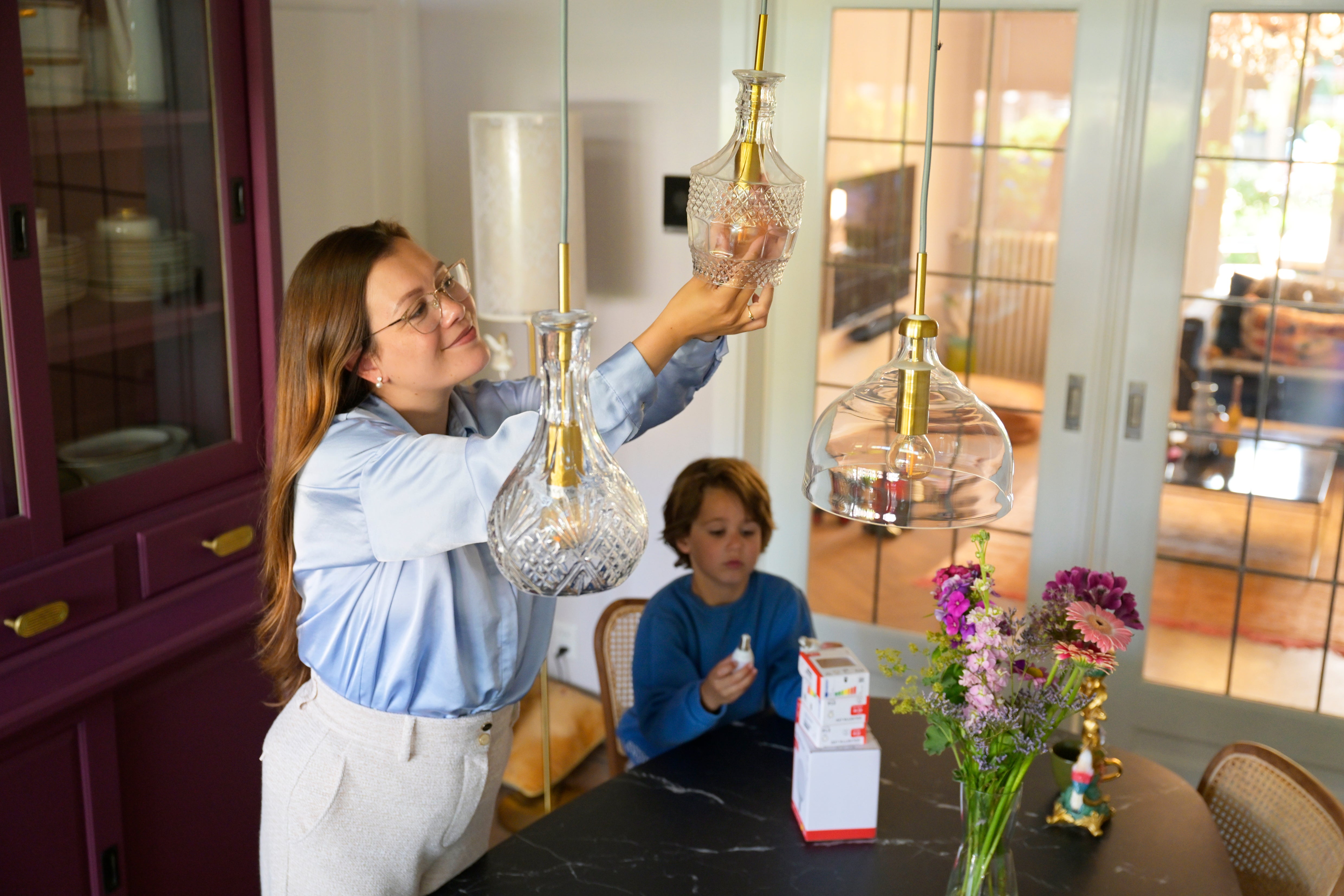 vrouw vervangt gloeilampen voor ledverlichting