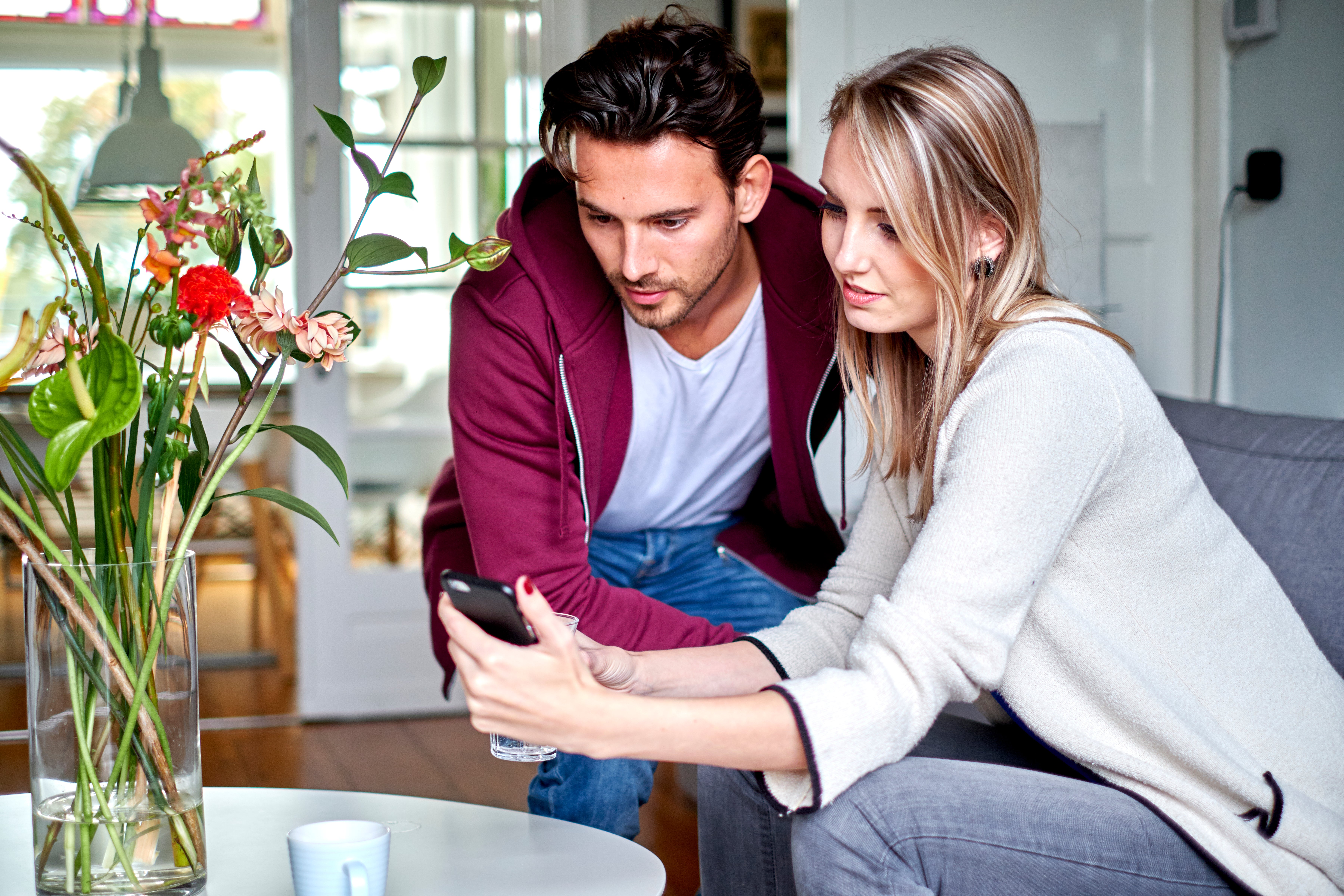 man en vrouw met telefoon in woonkamer