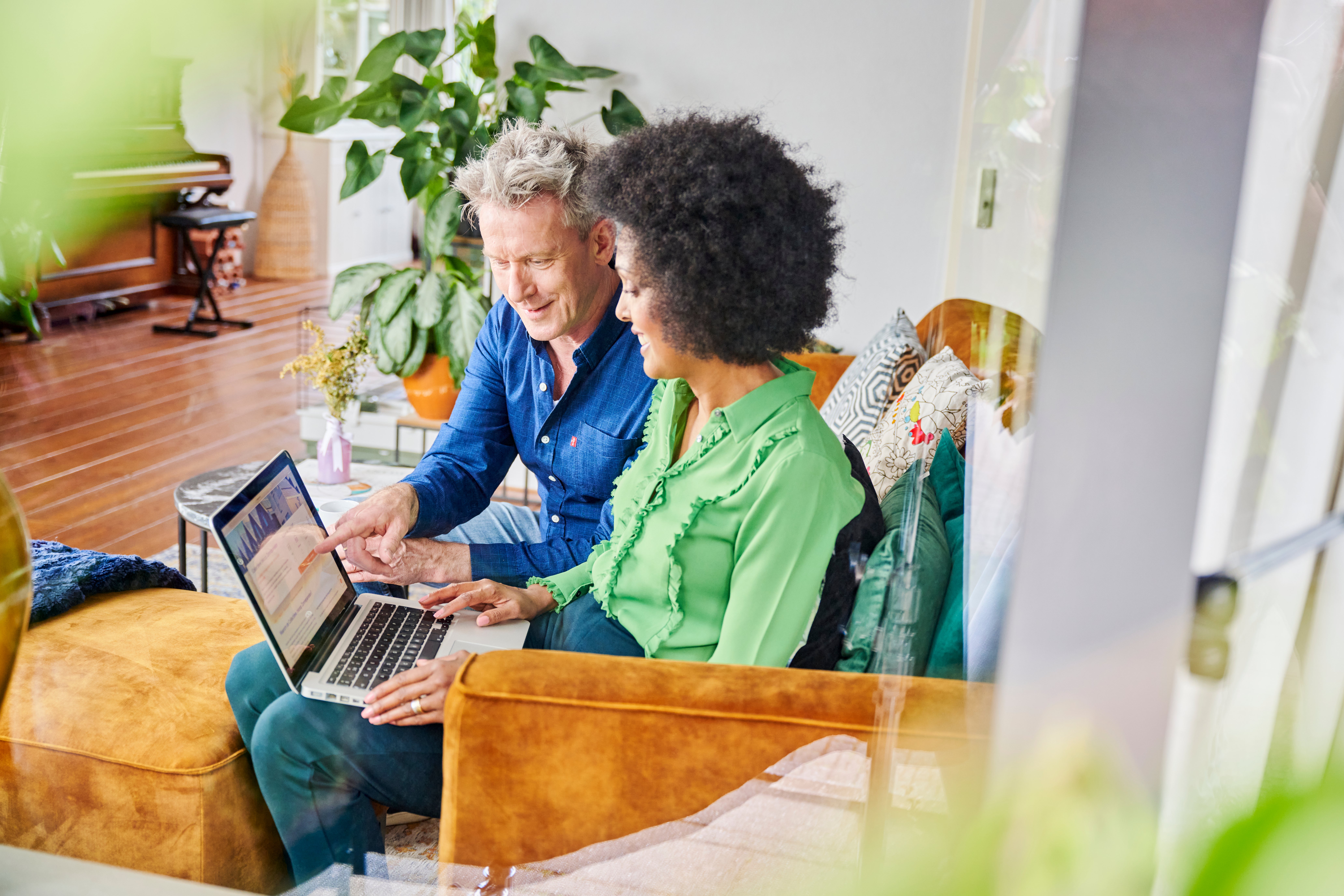 man en vrouw zitten op bank met laptop