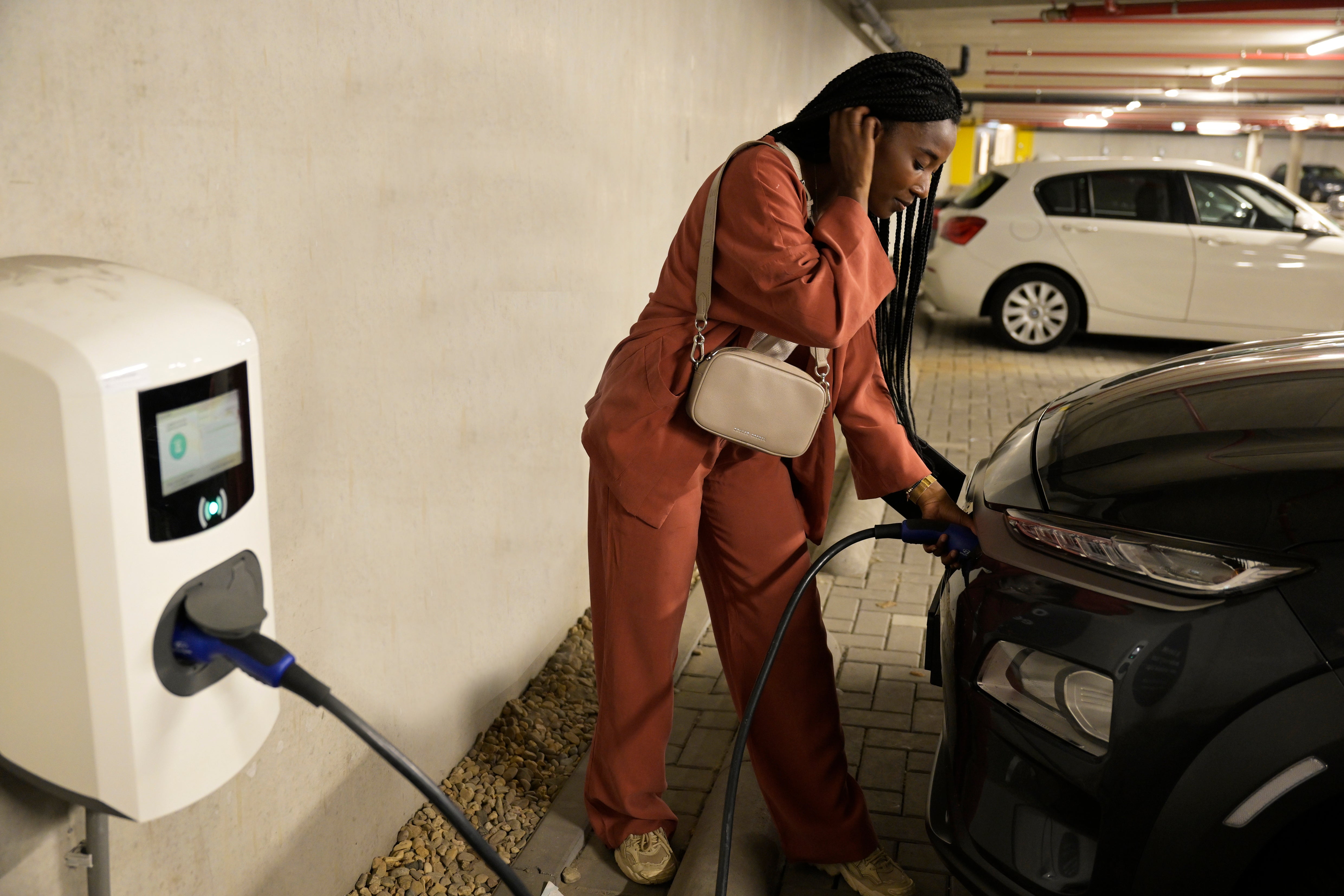 vrouw doet auto aan laadpaal