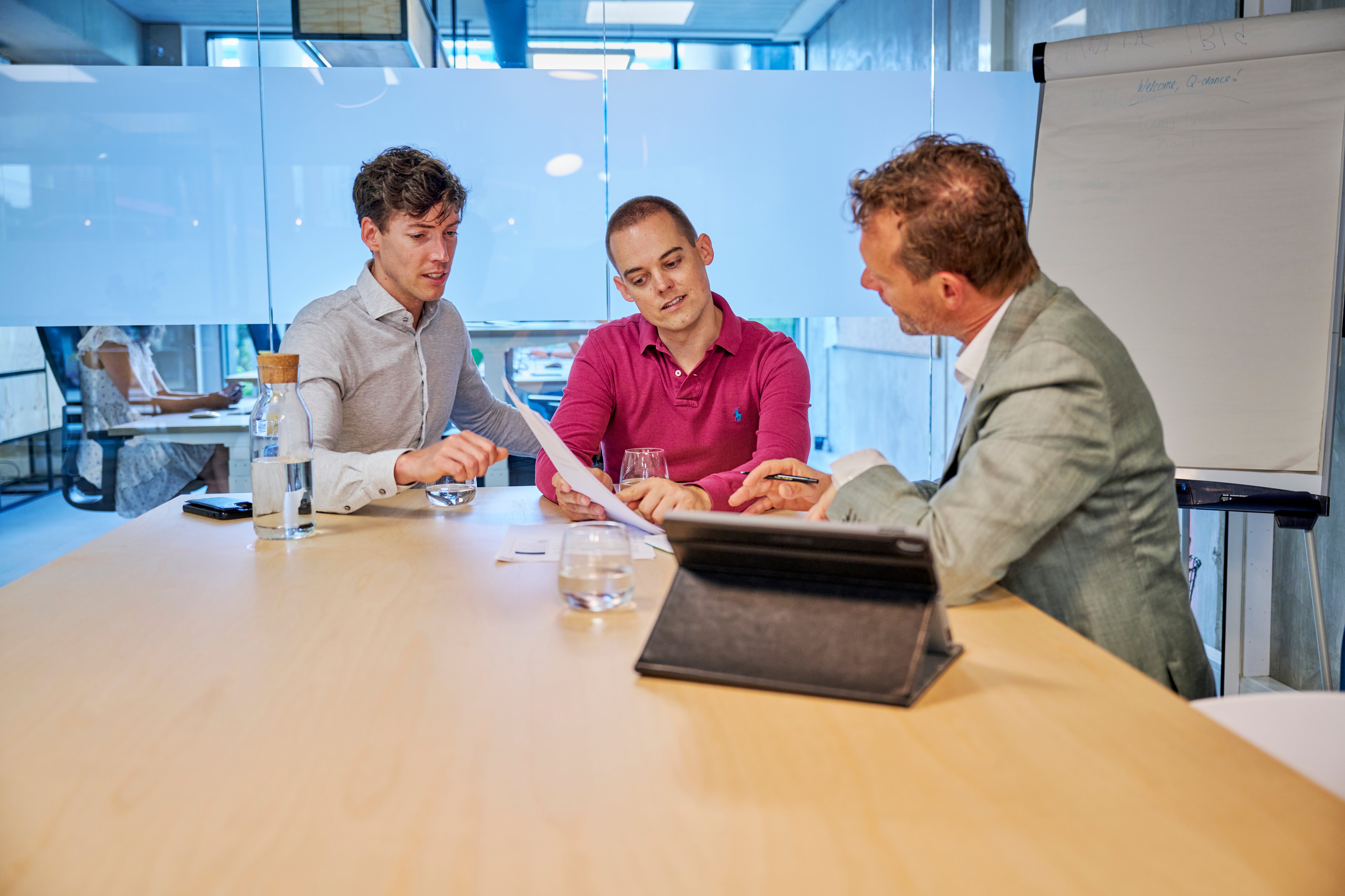 makelaar laat papier zien aan mannen