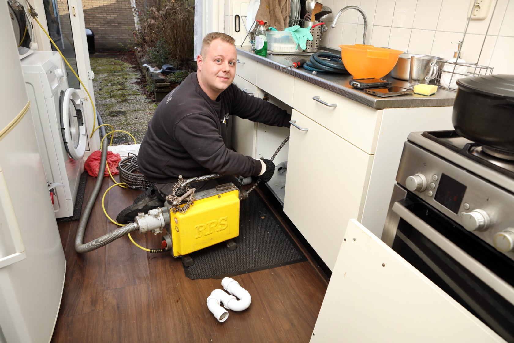 Ontstopper werkt in keukenkastje bij gootsteen