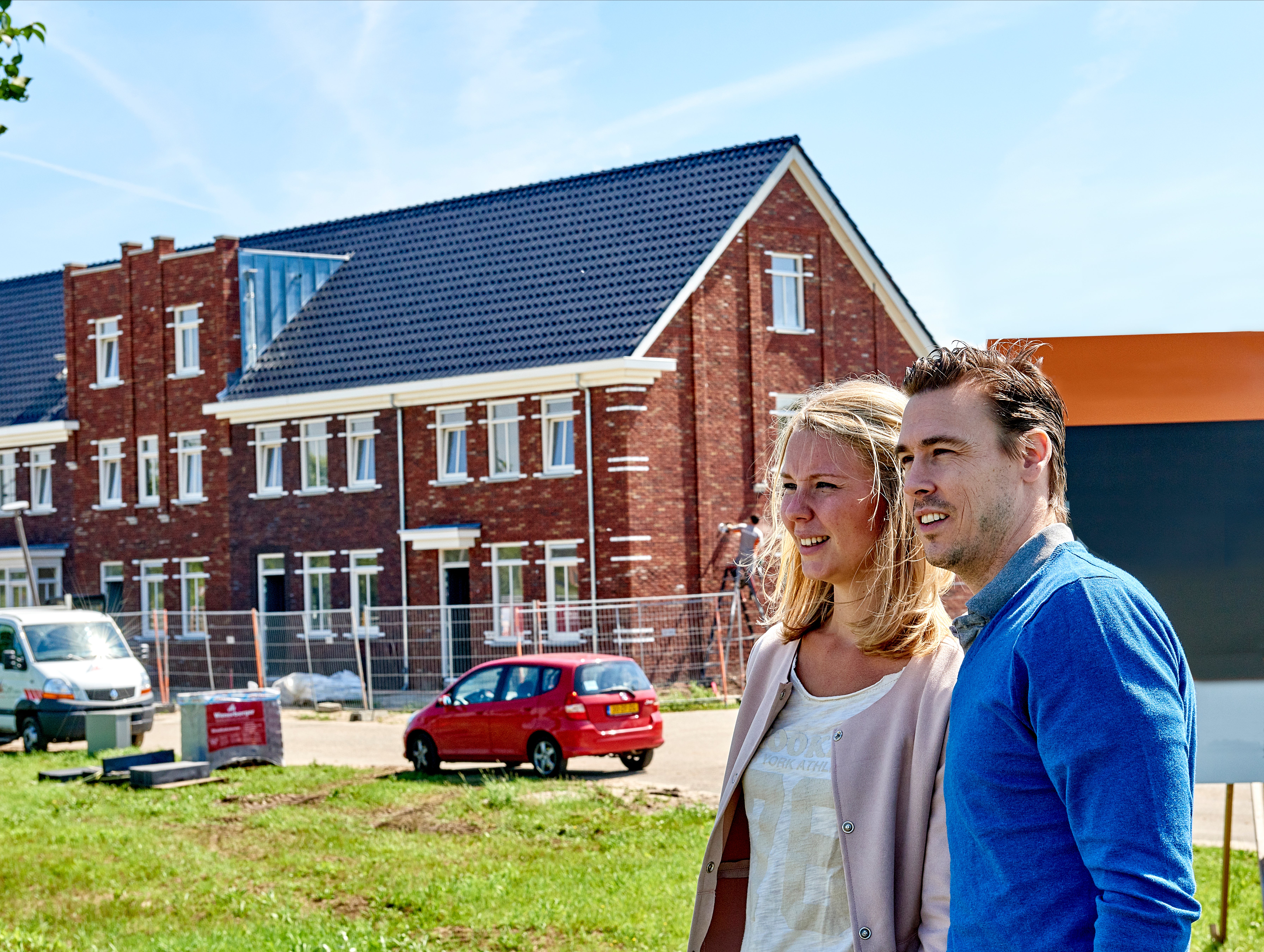 man en vrouw bekijken huizen in aanbouw
