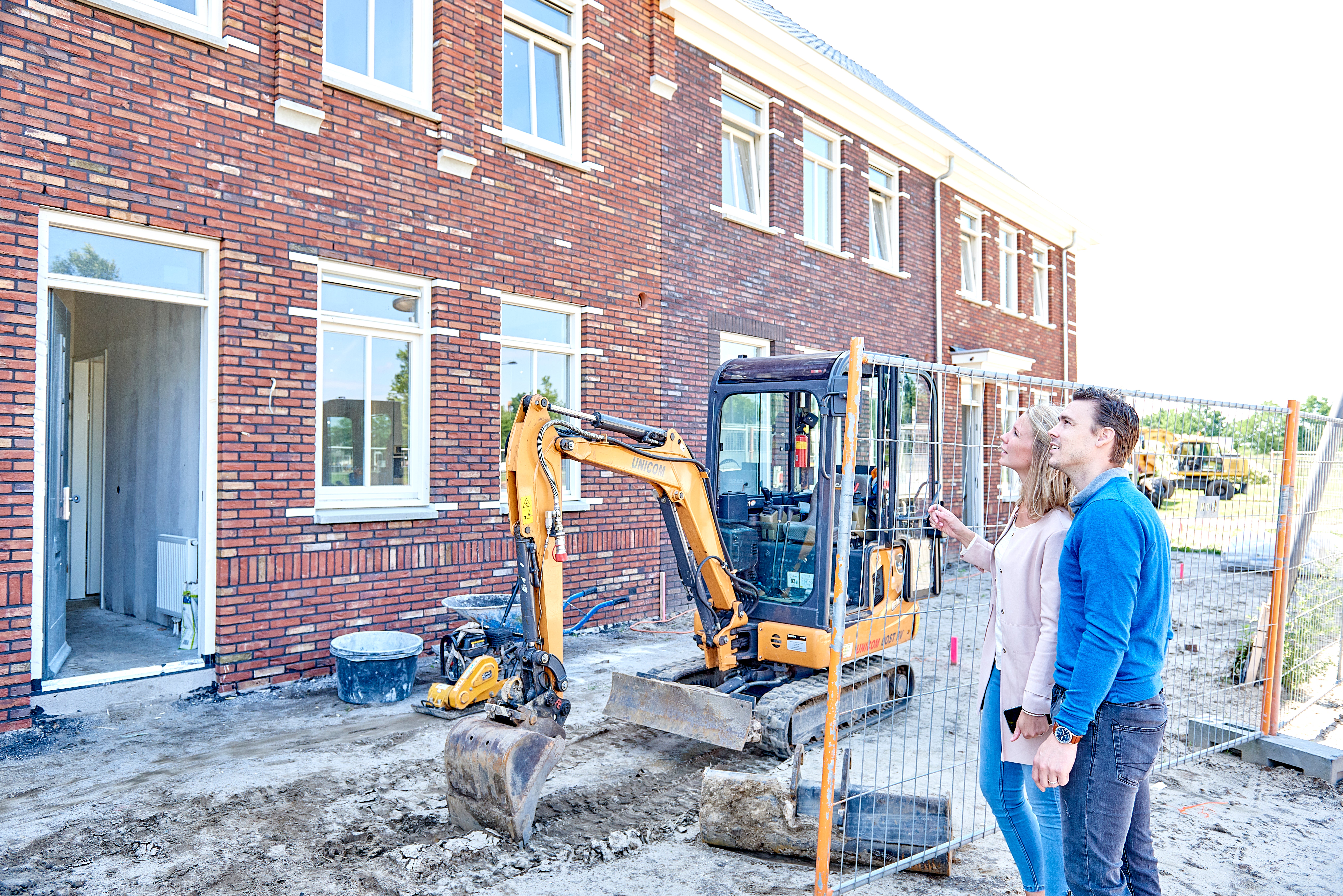 man en vrouw bekijken huizen in aanbouw