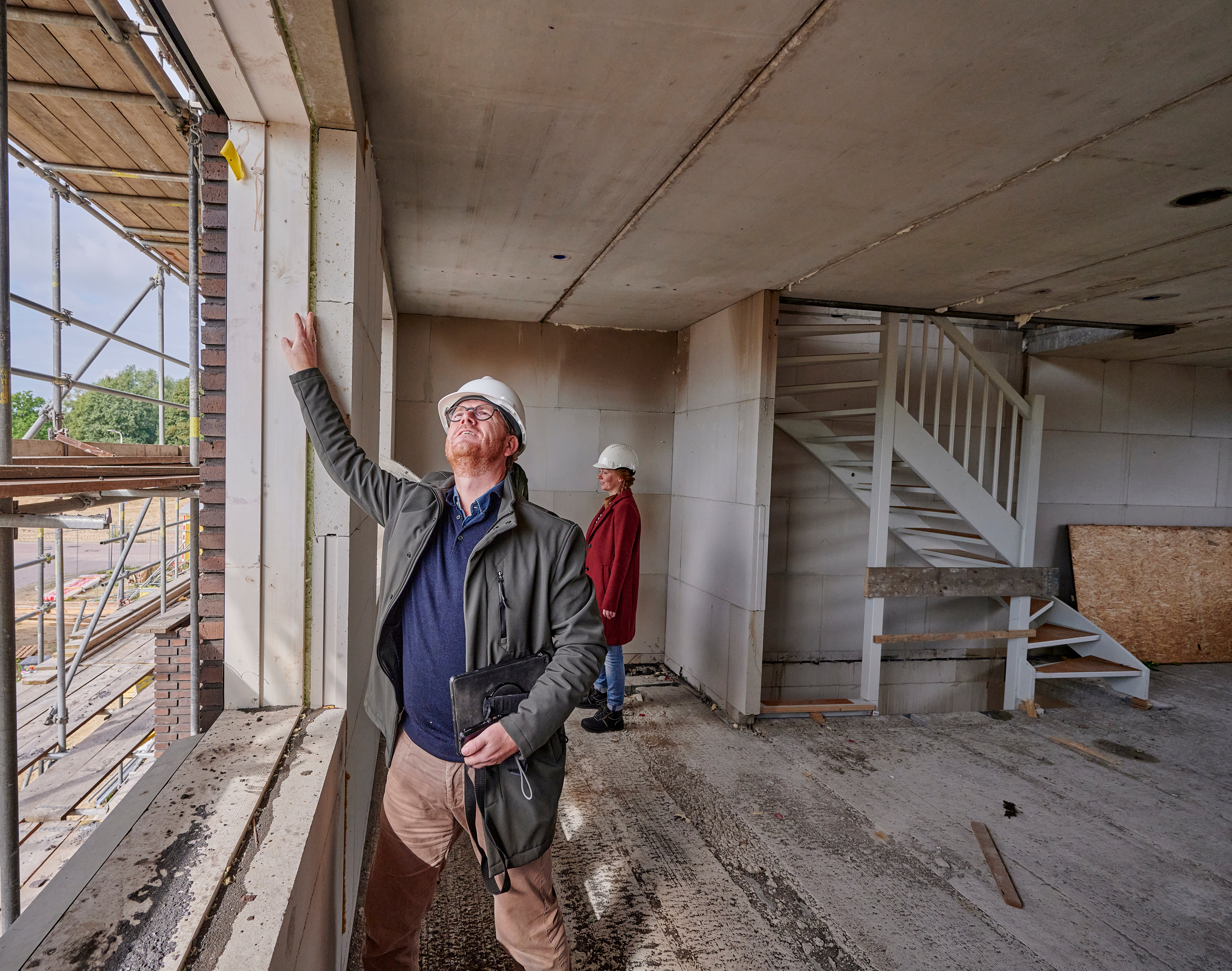 man kijkt naar raam in nieuwbouwwoning