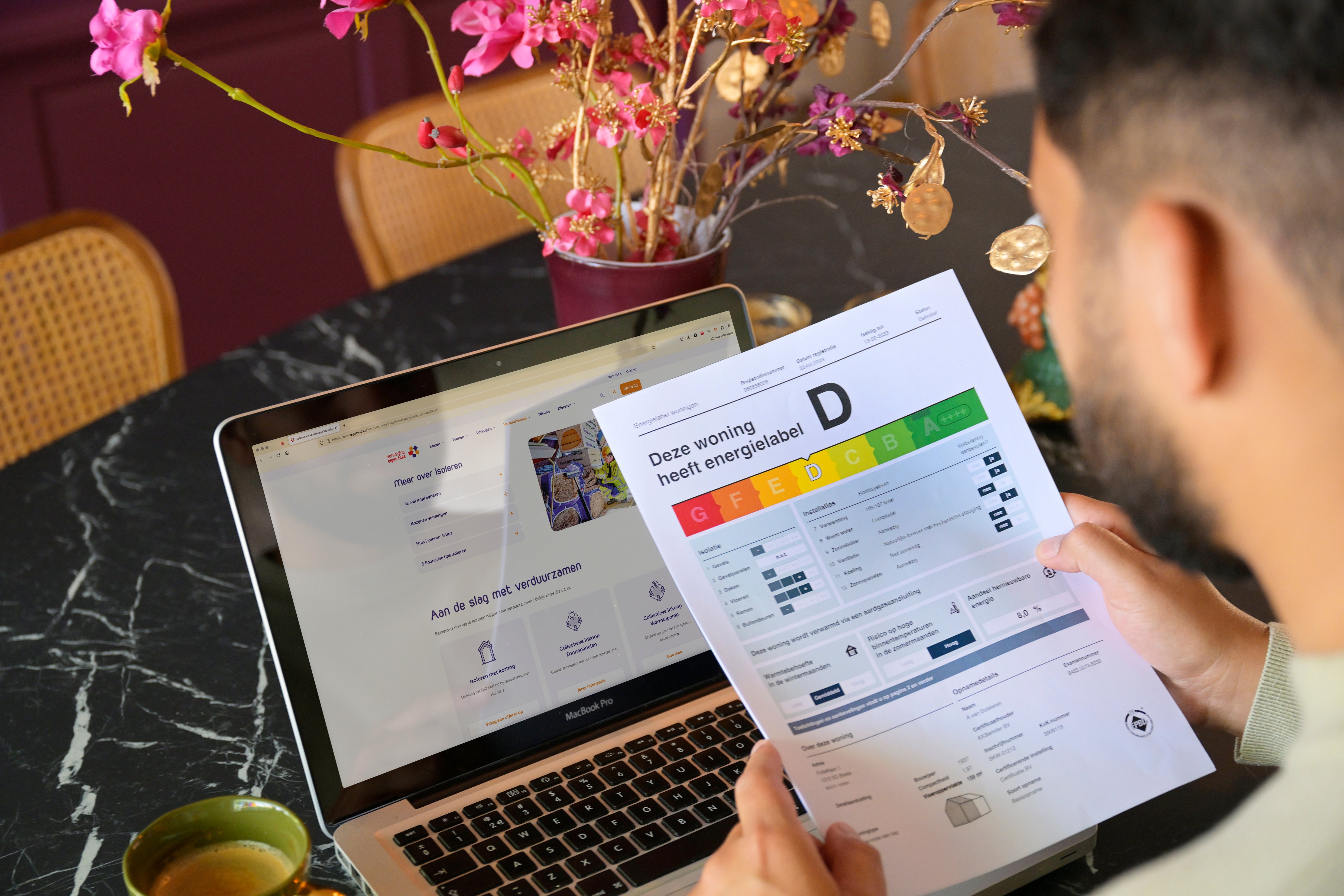 man met afgegeven energielabel rapport bij laptop