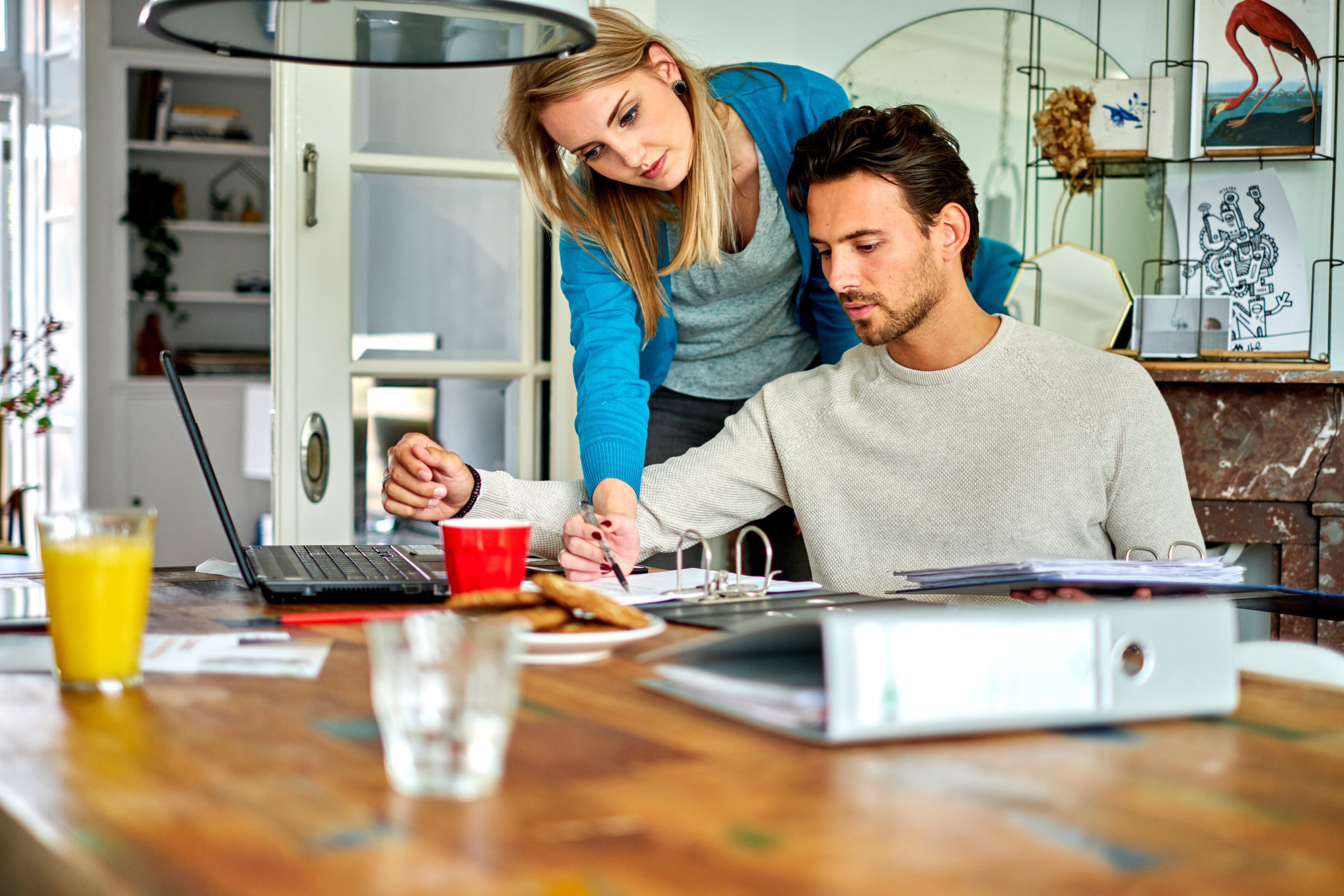 man en vrouw aan tafel bekijken papierwerk