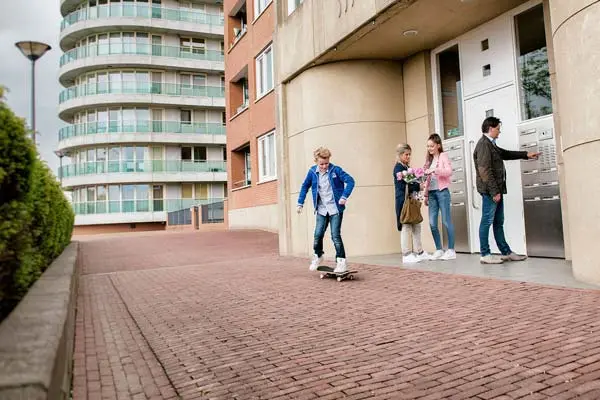 jongen op skateboard voor appartementencomplex