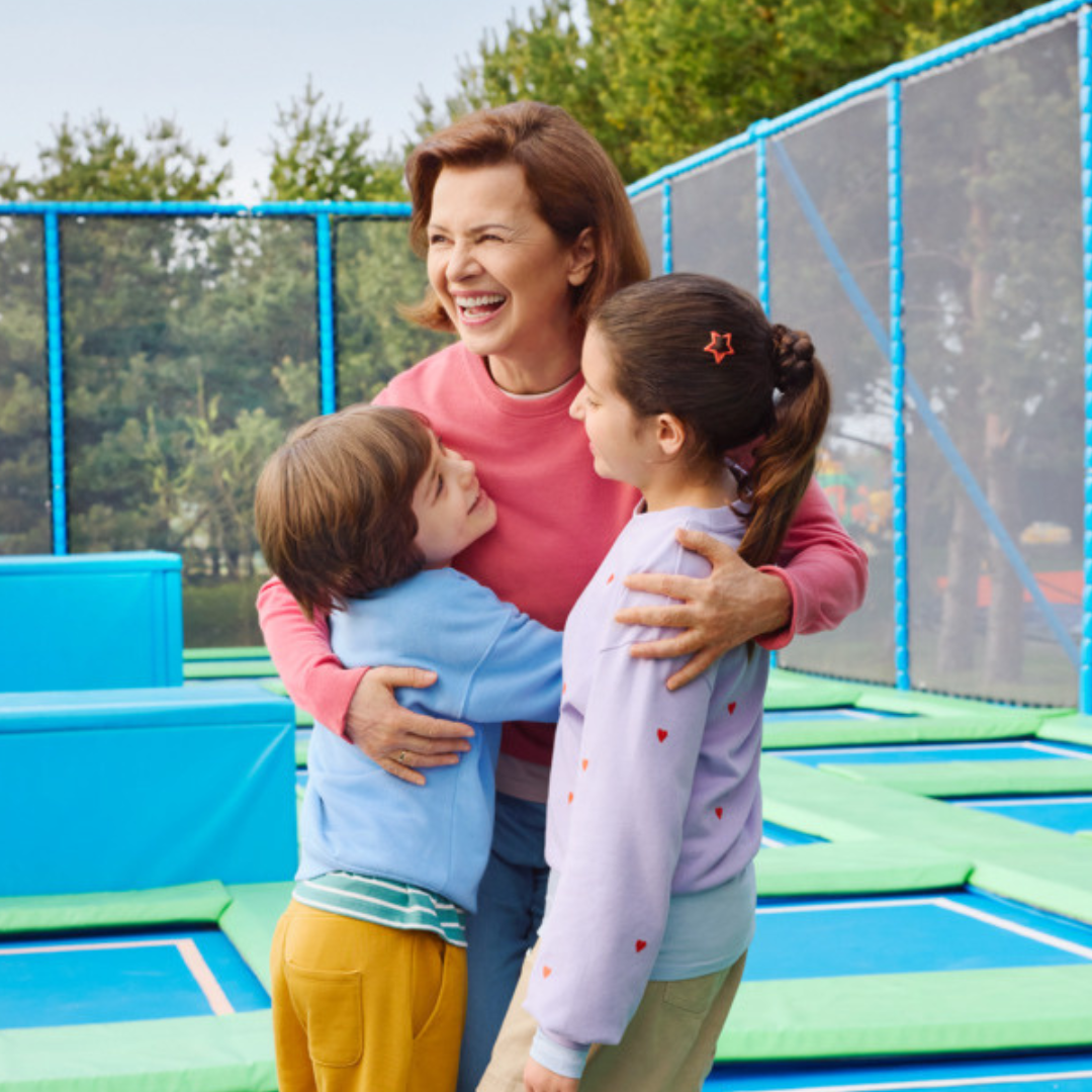 Frau mit Enkelkindern auf einem Trampolin
