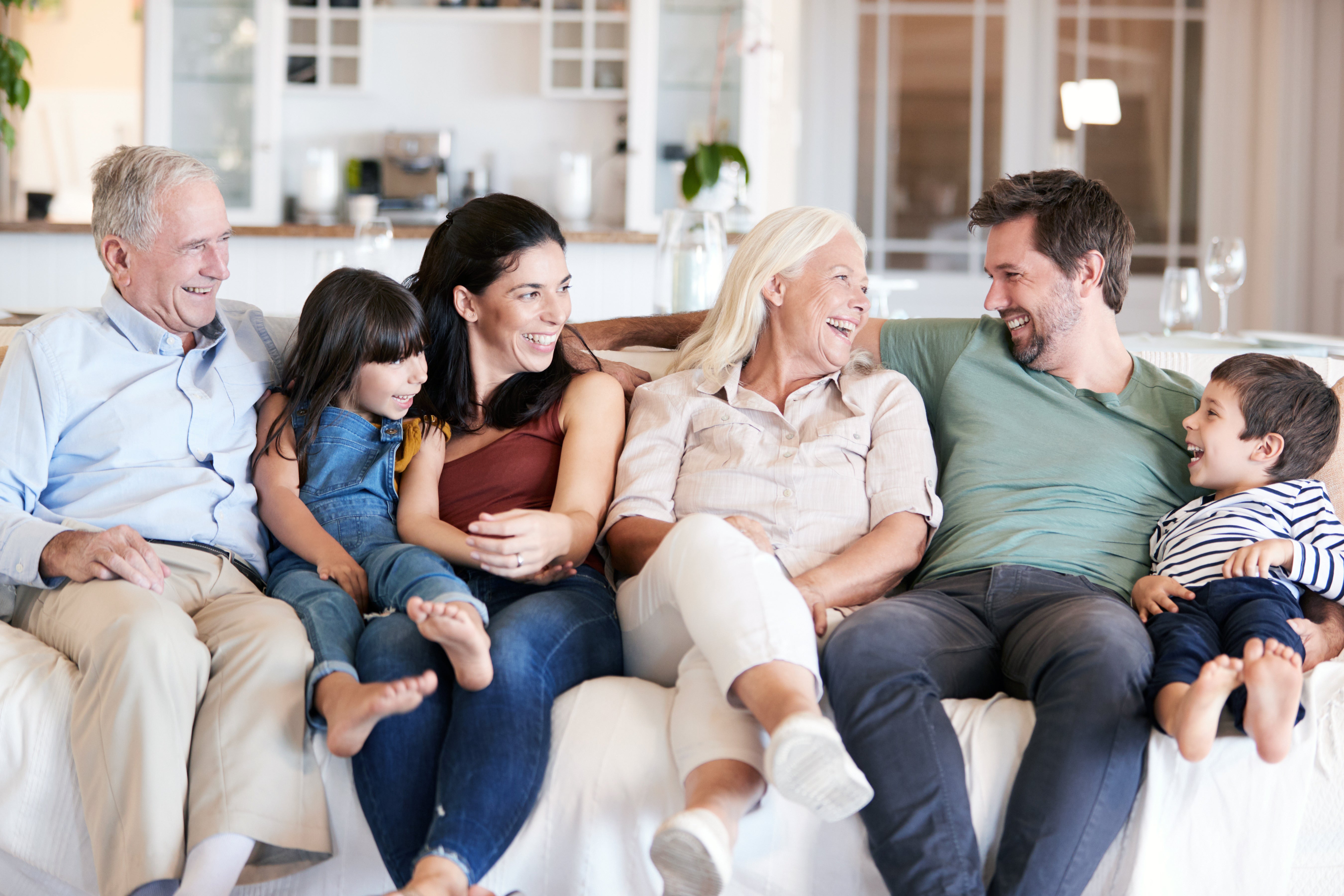 Famille avec grands-parents assis sur le canapé