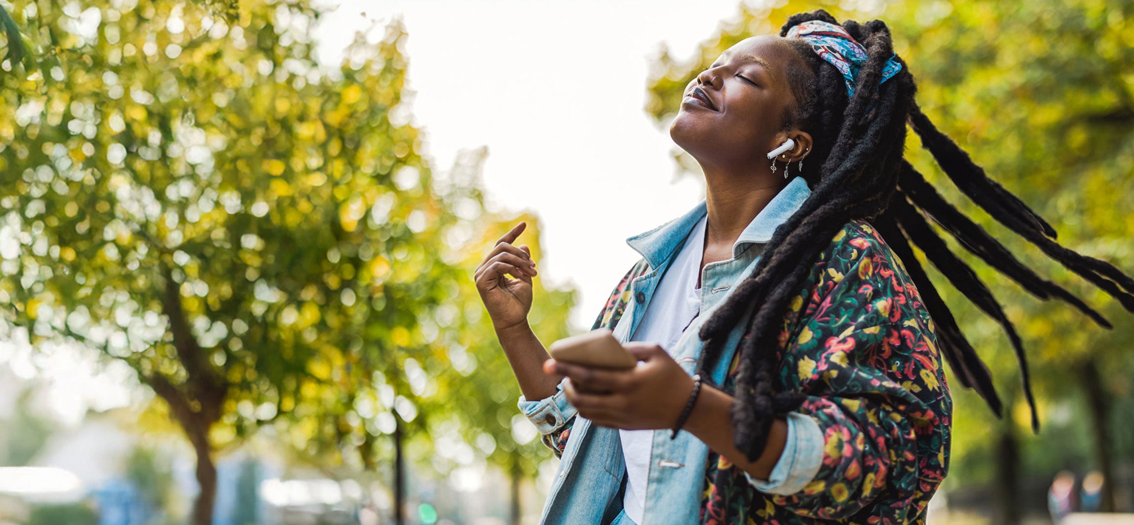A woman with her eyes closed and a phone in her hand