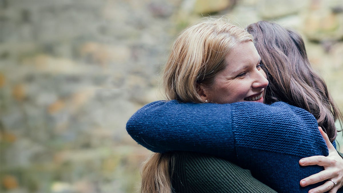 Two ladies hugging each other