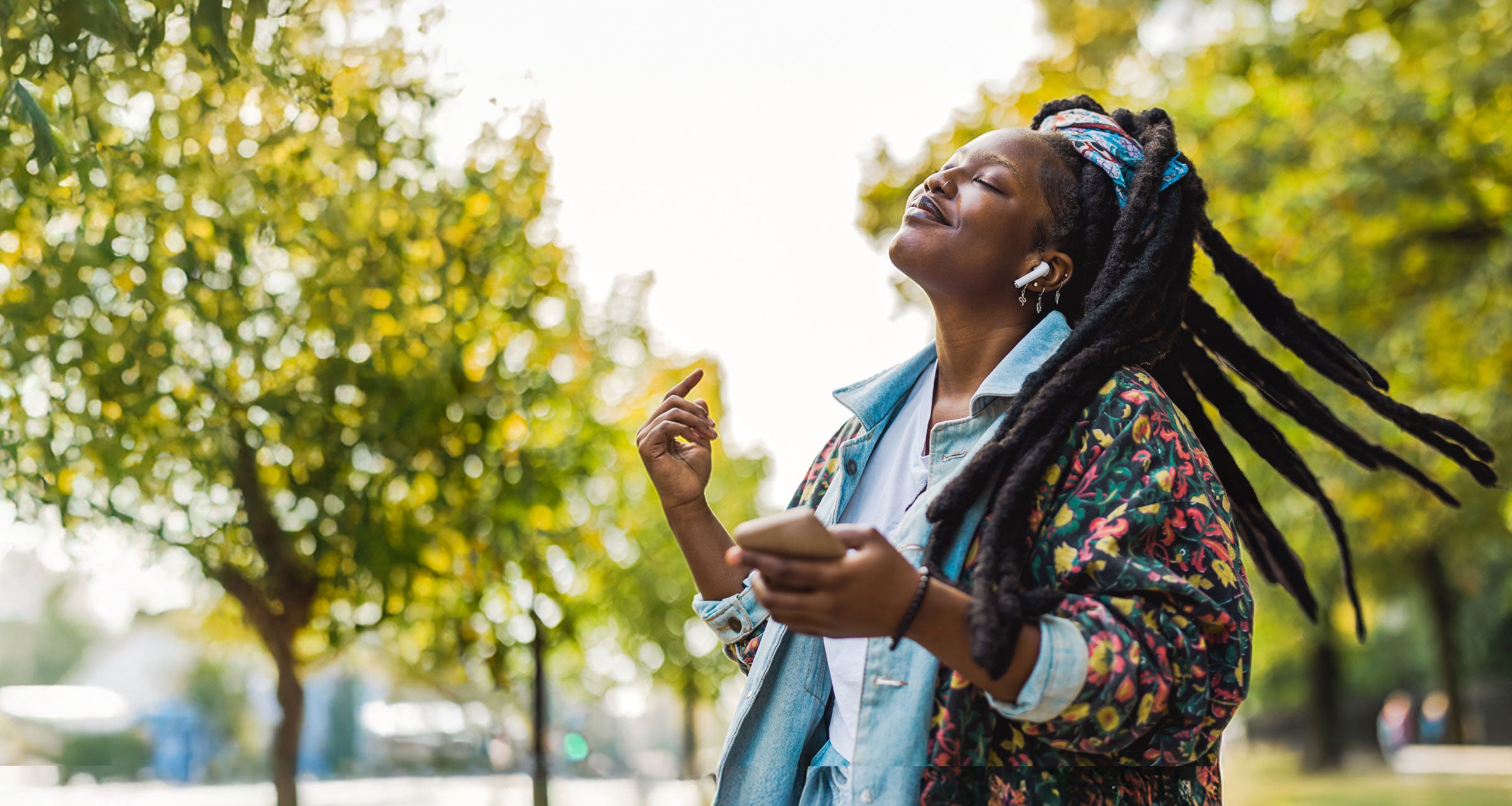 A woman with earphones holding a phone