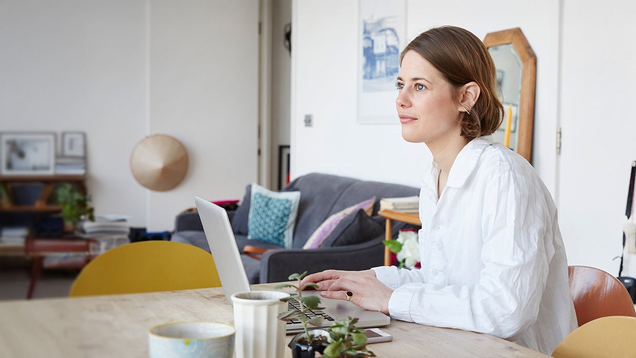 A woman sitting at a table with a laptop
