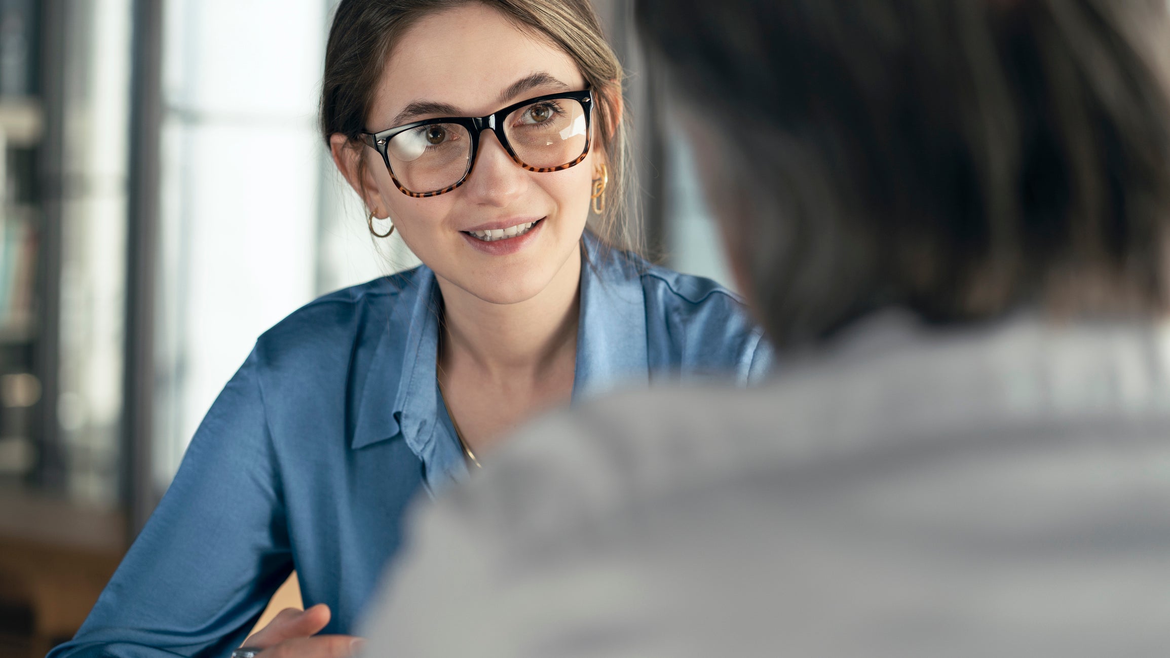 A woman wearing glasses and smiling