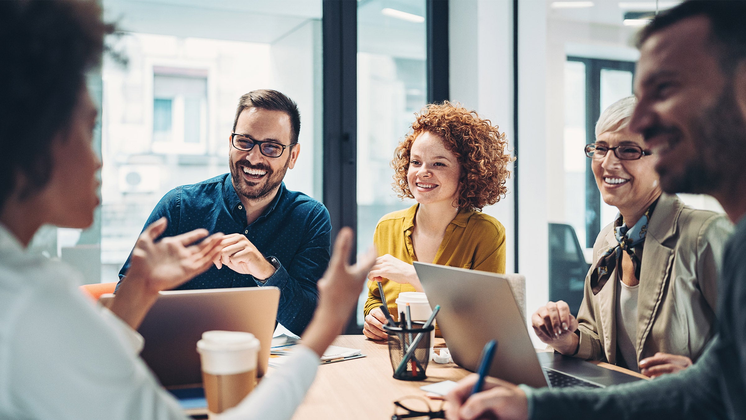 Employees having a good conversation, smiling at each other.