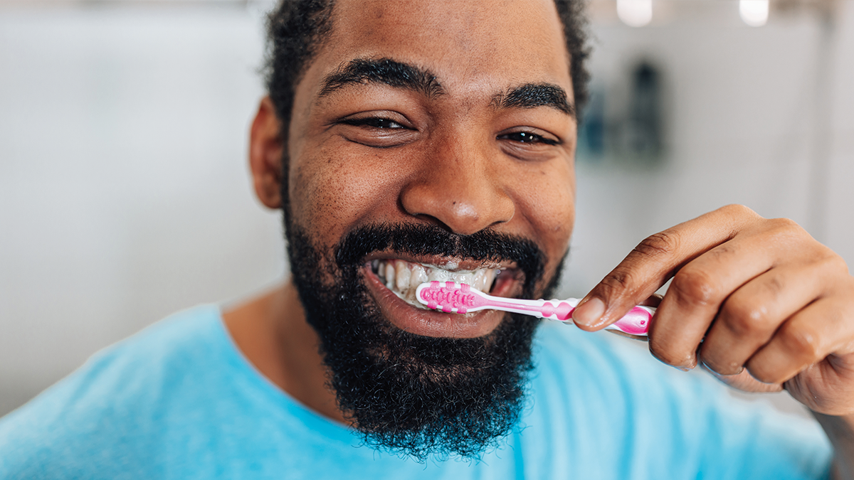 Man smiling brushing teeth