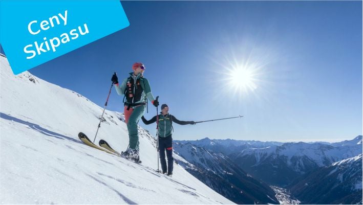 Dva skialpinisté na hřebeni nad Mölltalem v protisvětle, štítek Ceny skipasu