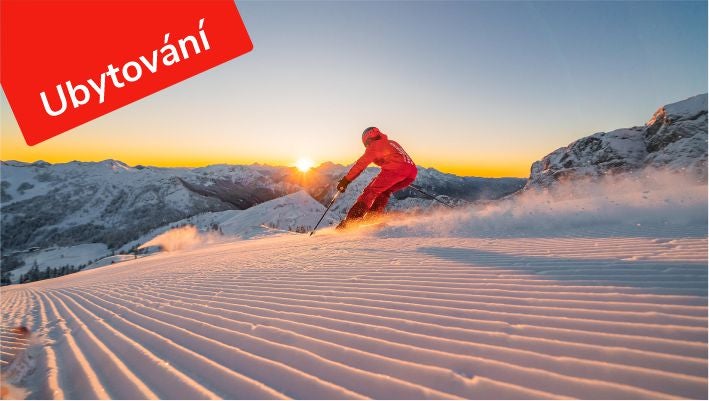 Lyžař na perfektně upravené sjezdovce v Nassfeldu při západu slunce, štítek Ubytování