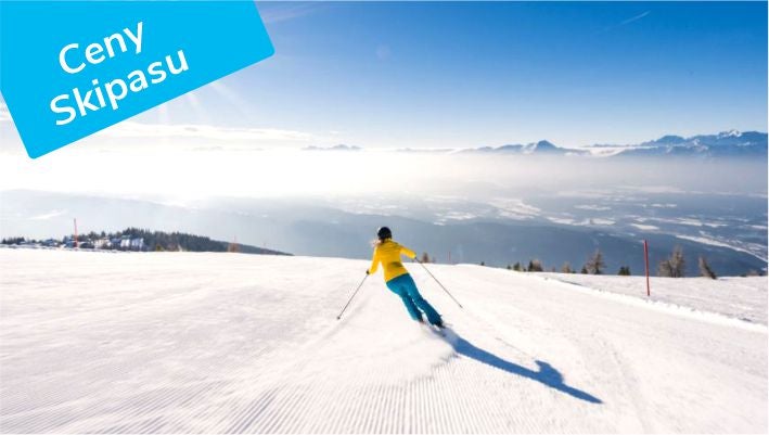 A skier on a groomed piste on the Gerlitzen above the valley fog, Ski pass prices label, © Michael Stabentheiner