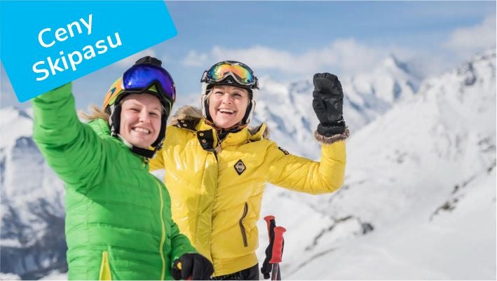 Two smiling skiers waving on the slopes at Heiligenblut, Ski pass prices label, © Franz Gerdl