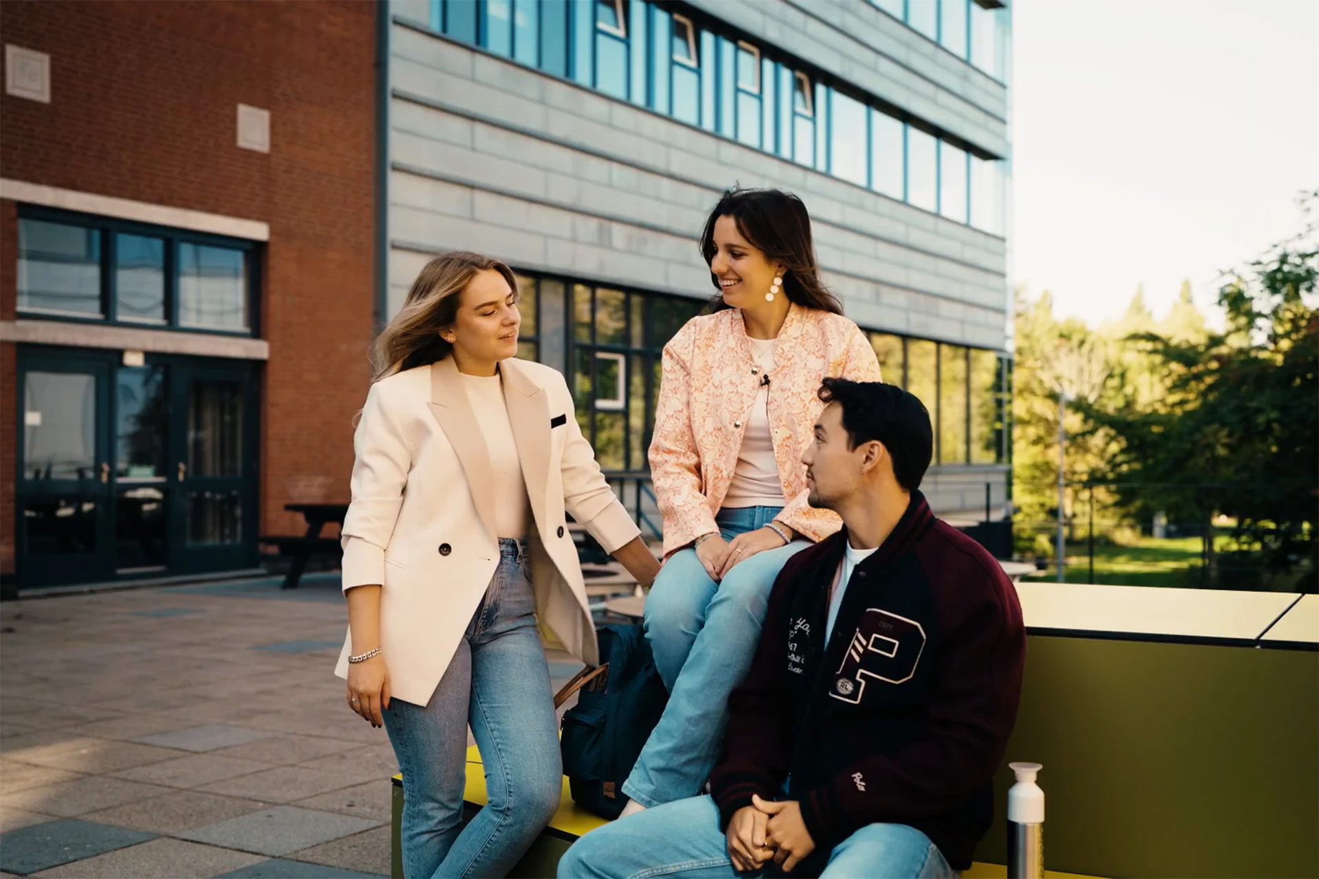 3 Avansstudenten zitten voor het Avans gebouw in Den Bosch