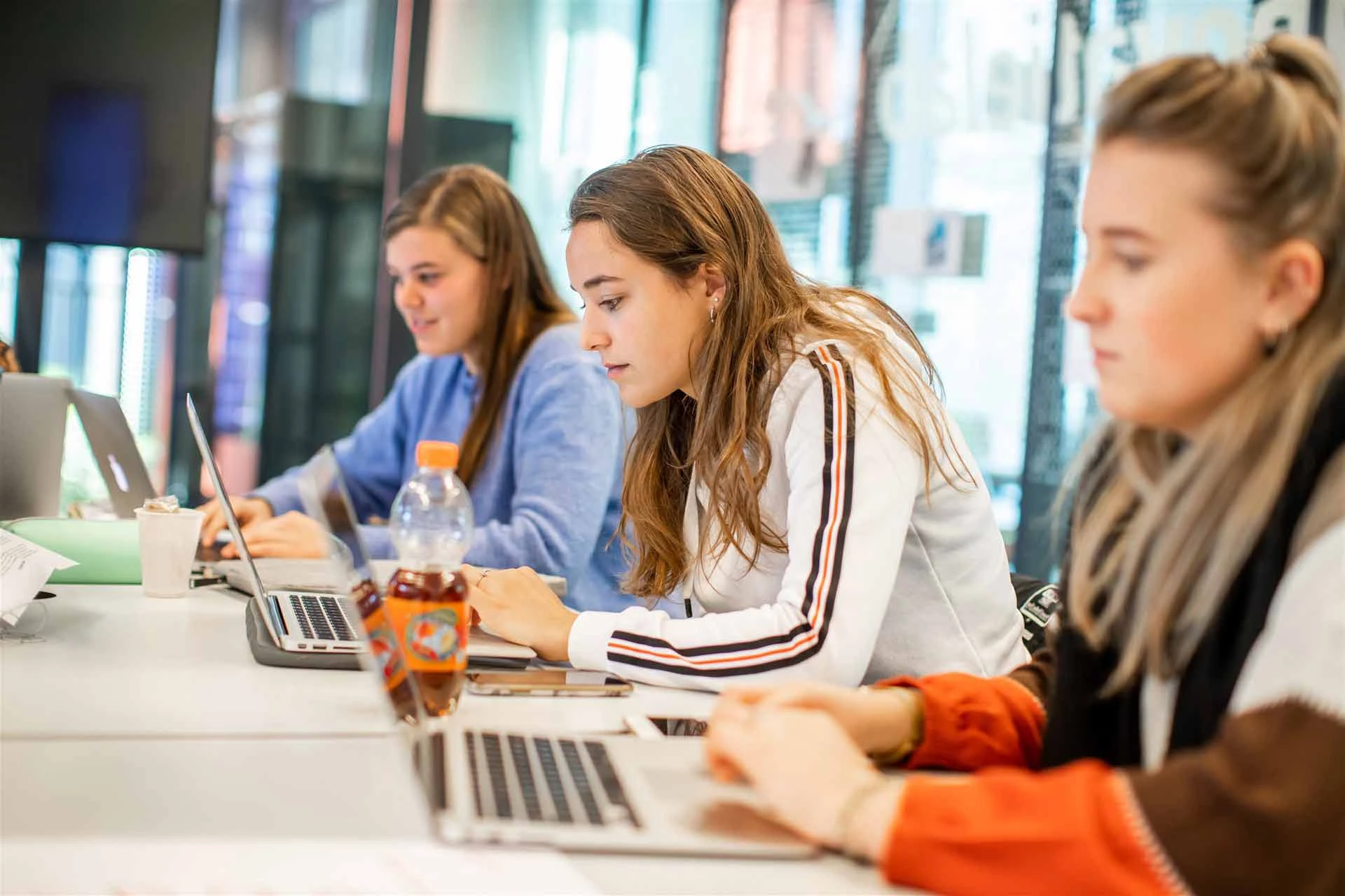 3 Avans studenten werken achter hun laptop aan een studieopdracht