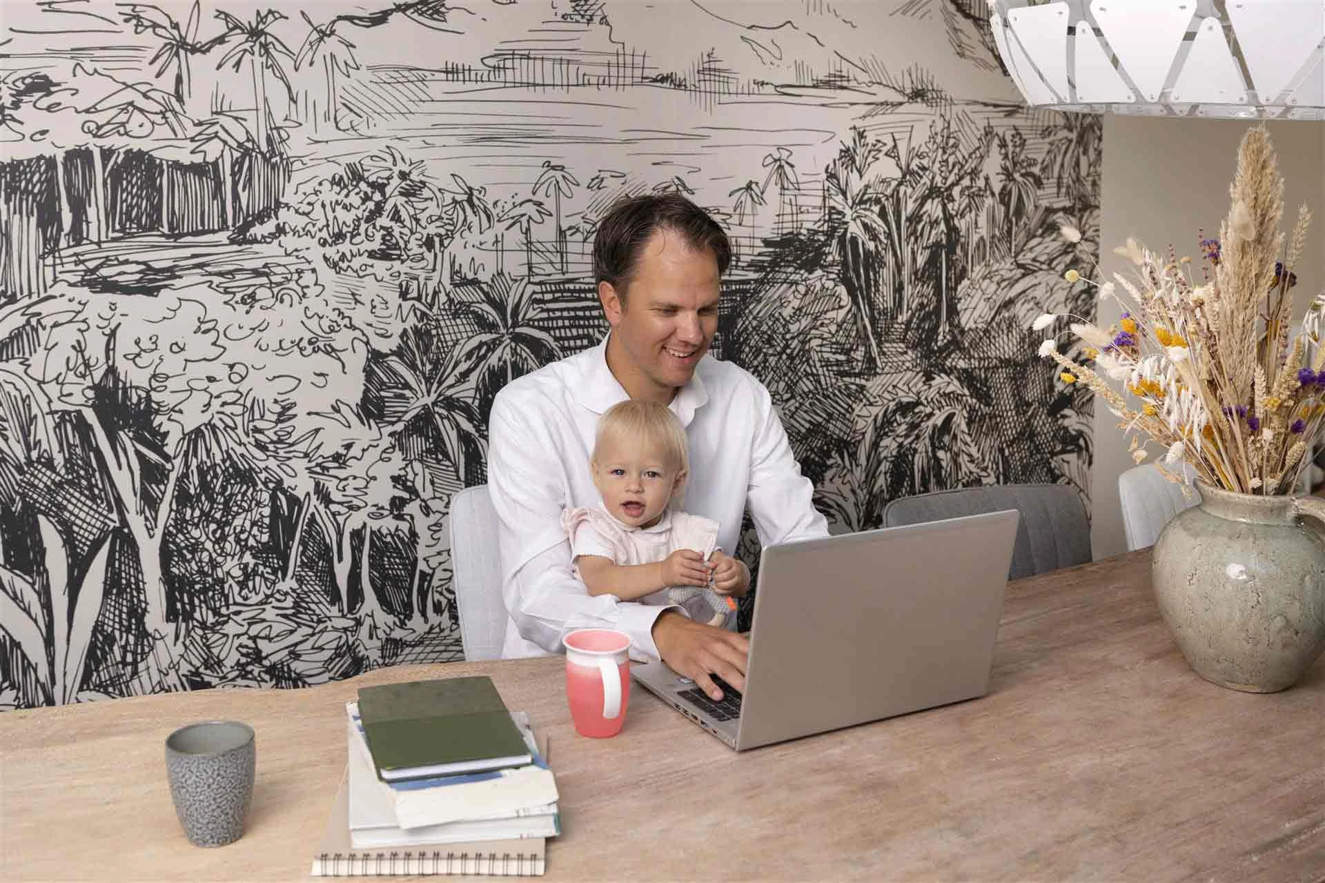 Vader zit met dochter van 2 jaar achter de laptop te werken aan zijn studie