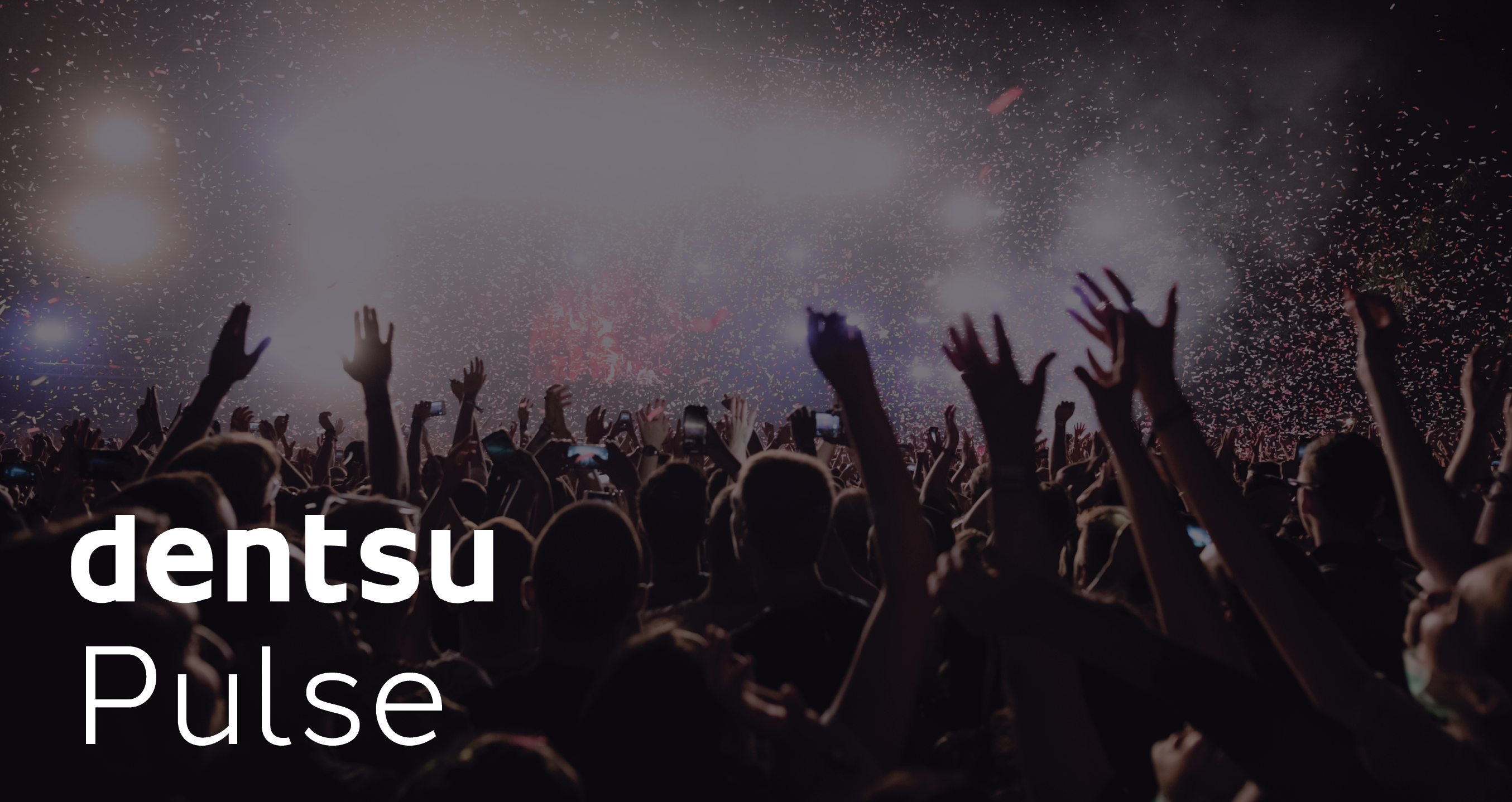 Audience at a live event with raised hands and confetti in the air, overlaid with the text 'dentsu Pulse' in white.