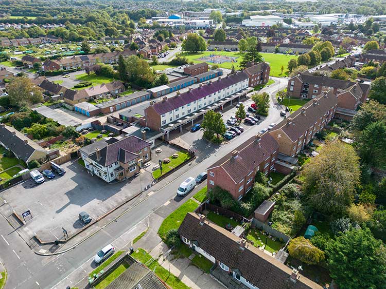 Aerial view of a residential neighbourhood with housing, roads and green spaces.