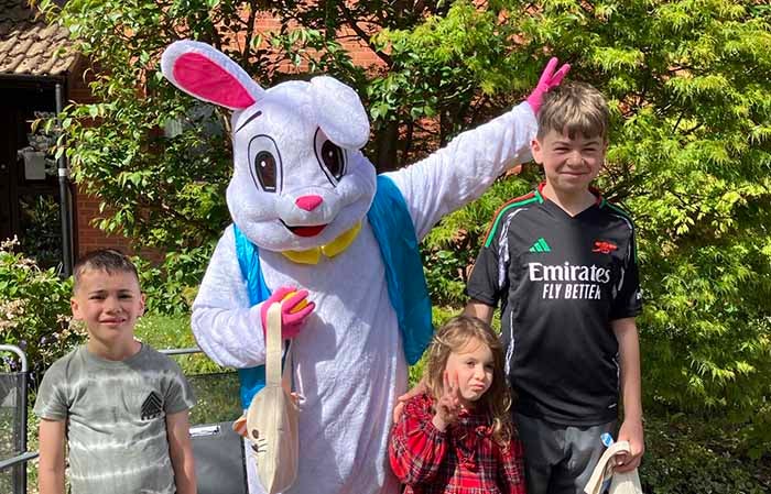 A bunny rabbit next to three children