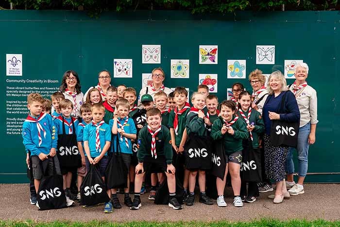 Scouts pose in front of Welwyn hoarding