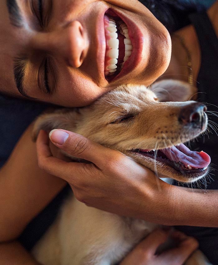 A woman cuddling a dog