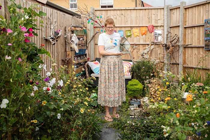 Willow May in her garden with In Bloom trophy