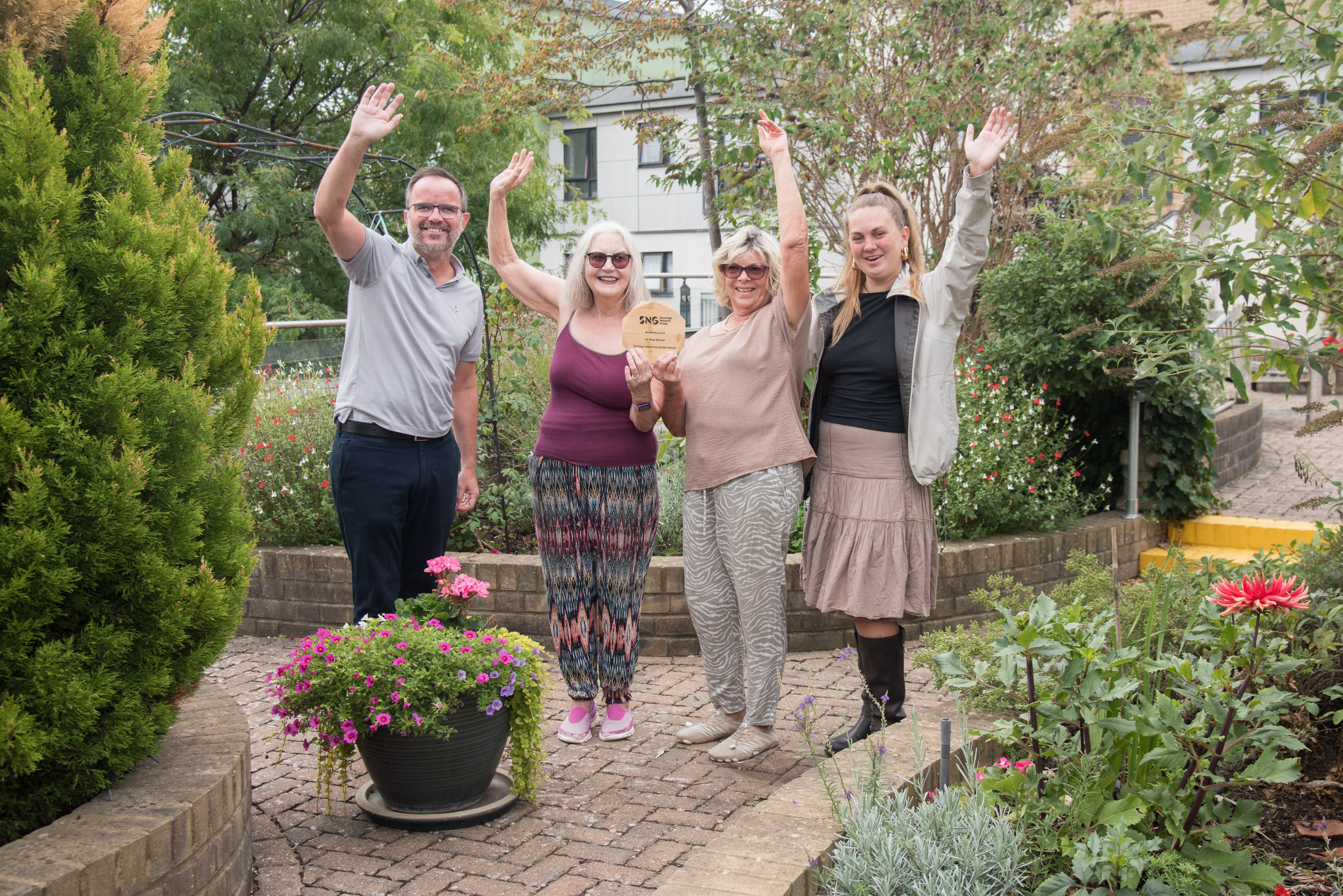 Community garden winners and SNG staff celebrating with the trophy