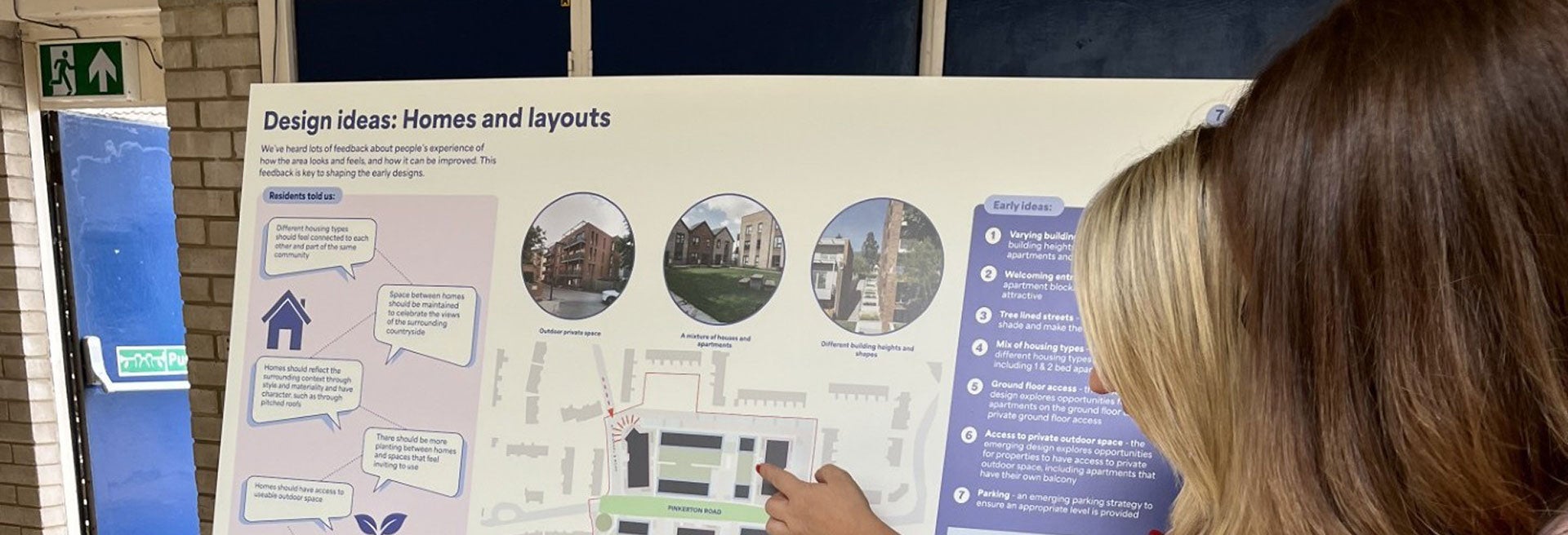 Community member reviewing proposed homes and site layout plans at a consultation event.