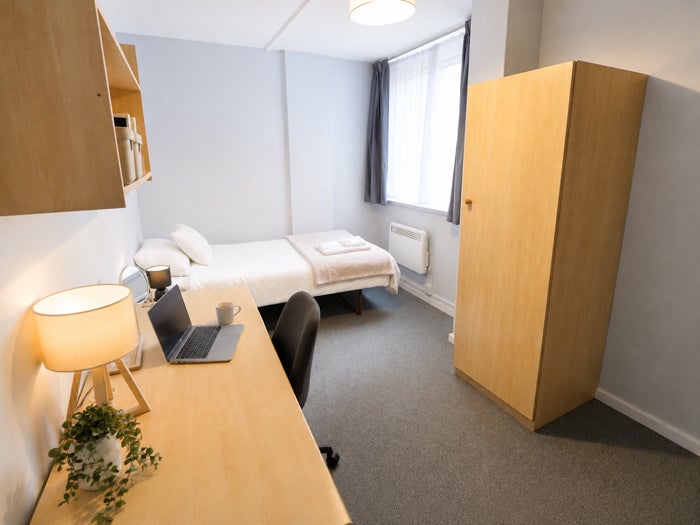 Furnished single bedroom with study area and wardrobe