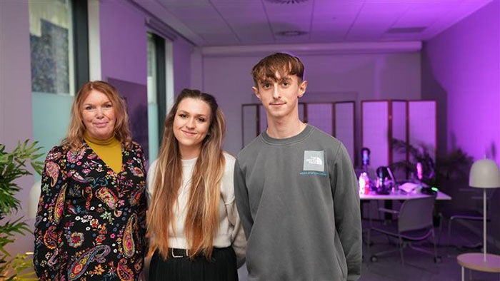 Three people standing in a radio studio