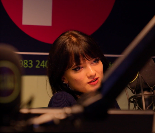 A young girl sat in a radio studio